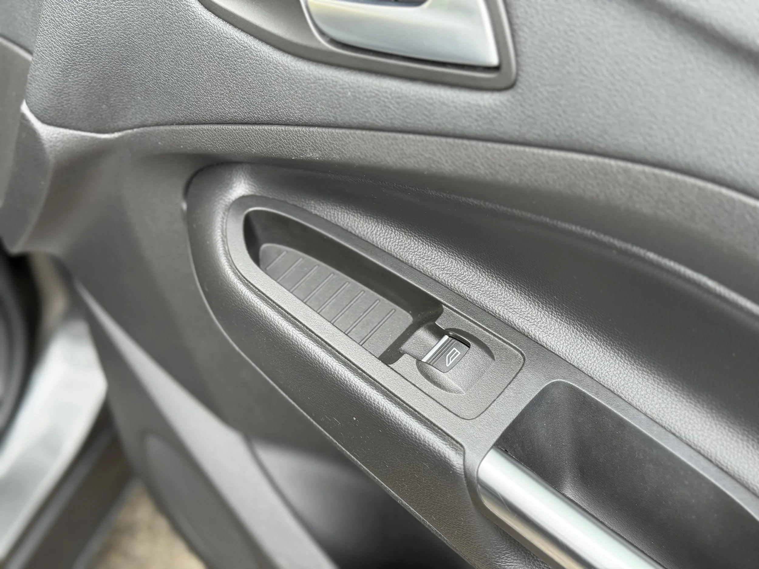 Car door interior with window control switch and handle