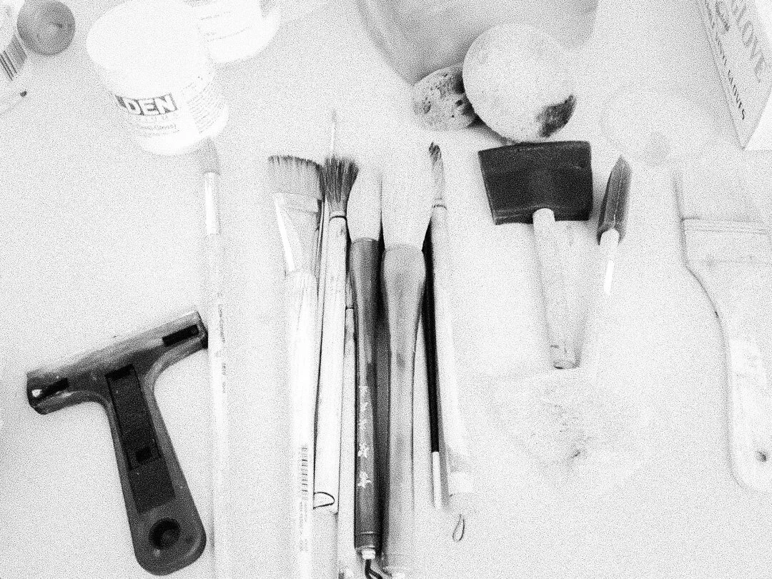 Behind the scenes art studio, precision instruments laid out on a white surface. 