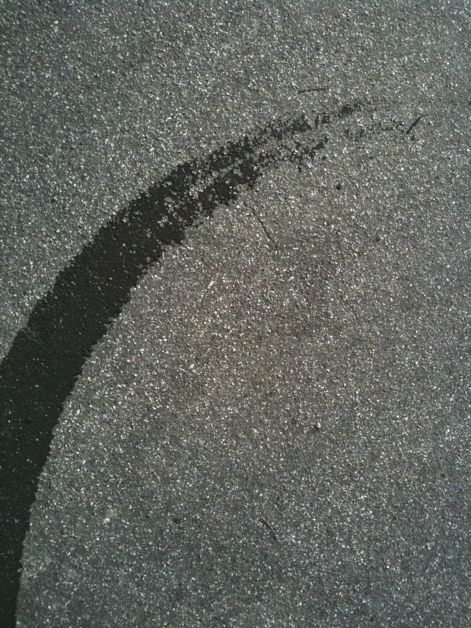 Dark asphalt pavement with a black painted number 2 and some small cracks.
