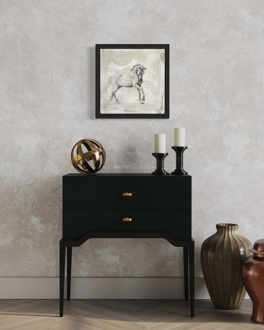 A black console table with two drawers, topped with a metallic spherical sculpture and two tall white candles on black candleholders. Above the table hangs a framed sketch of a horse on a light-colored wall, with large decorative vases on the floor b