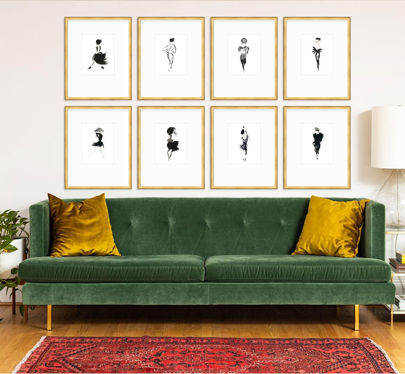 Living room with green velvet sofa, yellow pillows, gallery wall with eight black and white abstract art prints, framed in gold. Red patterned rug, lamp, and plant.