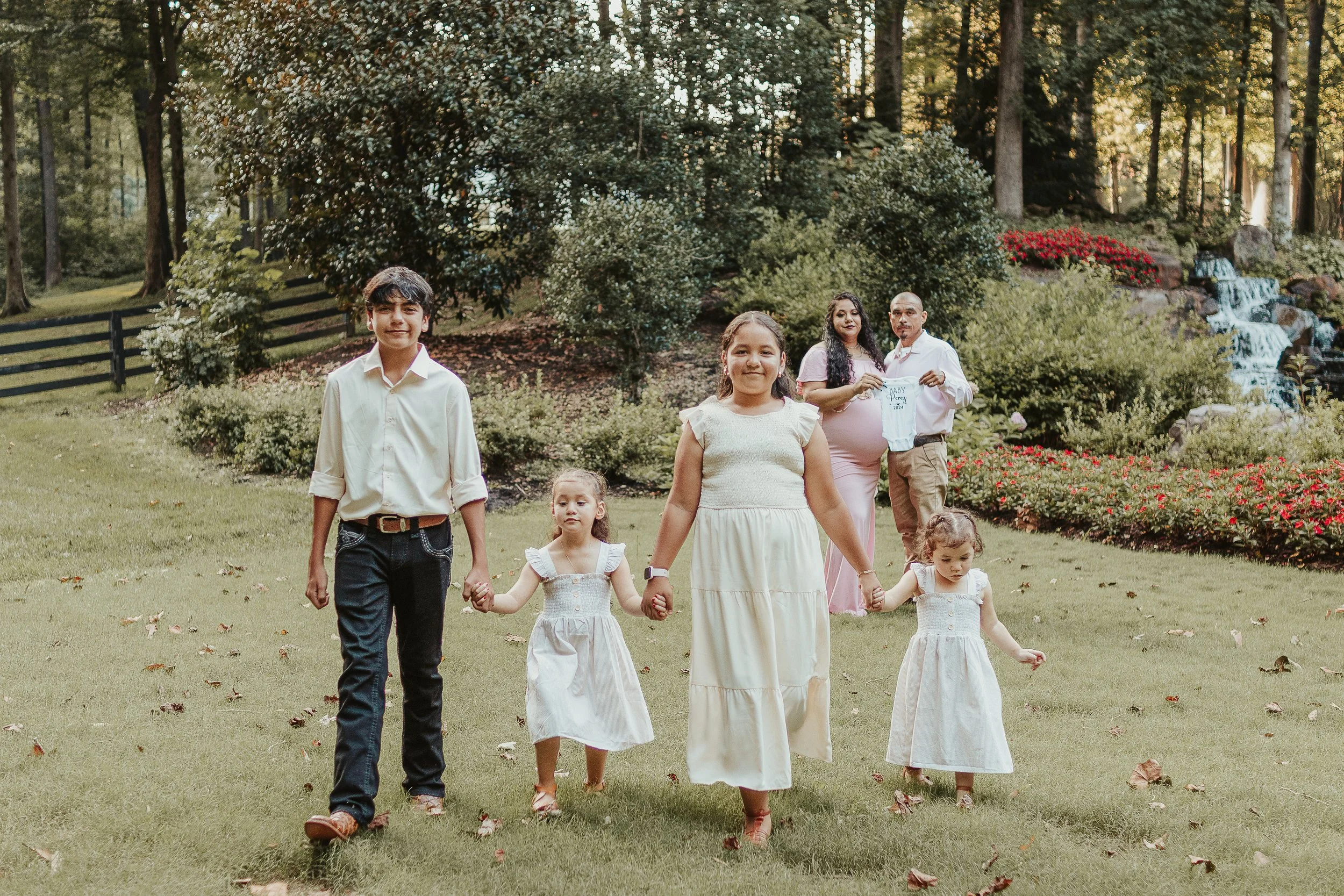 Family maternity portrait with four kids in front and parents standing behind them.