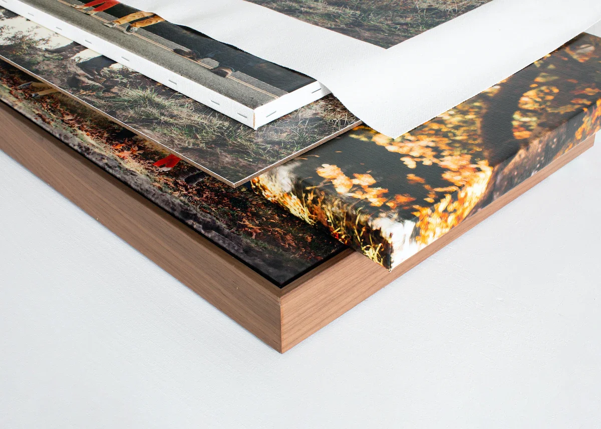 Close-up of a layered art piece or portfolio with various photographs and textured papers on top of a wooden board.