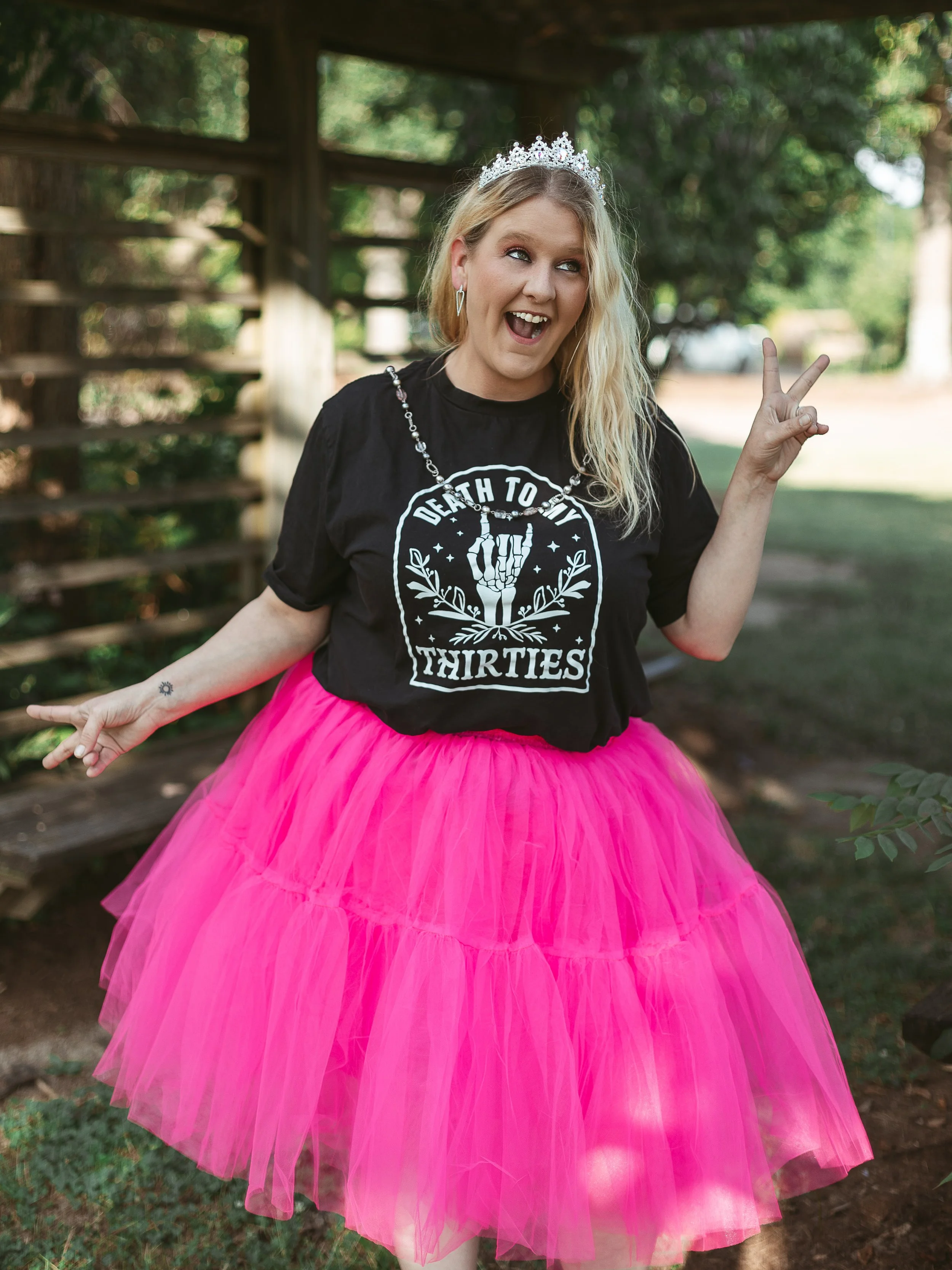 Playful 40th birthday portrait of woman celebrating in a pink tutu.