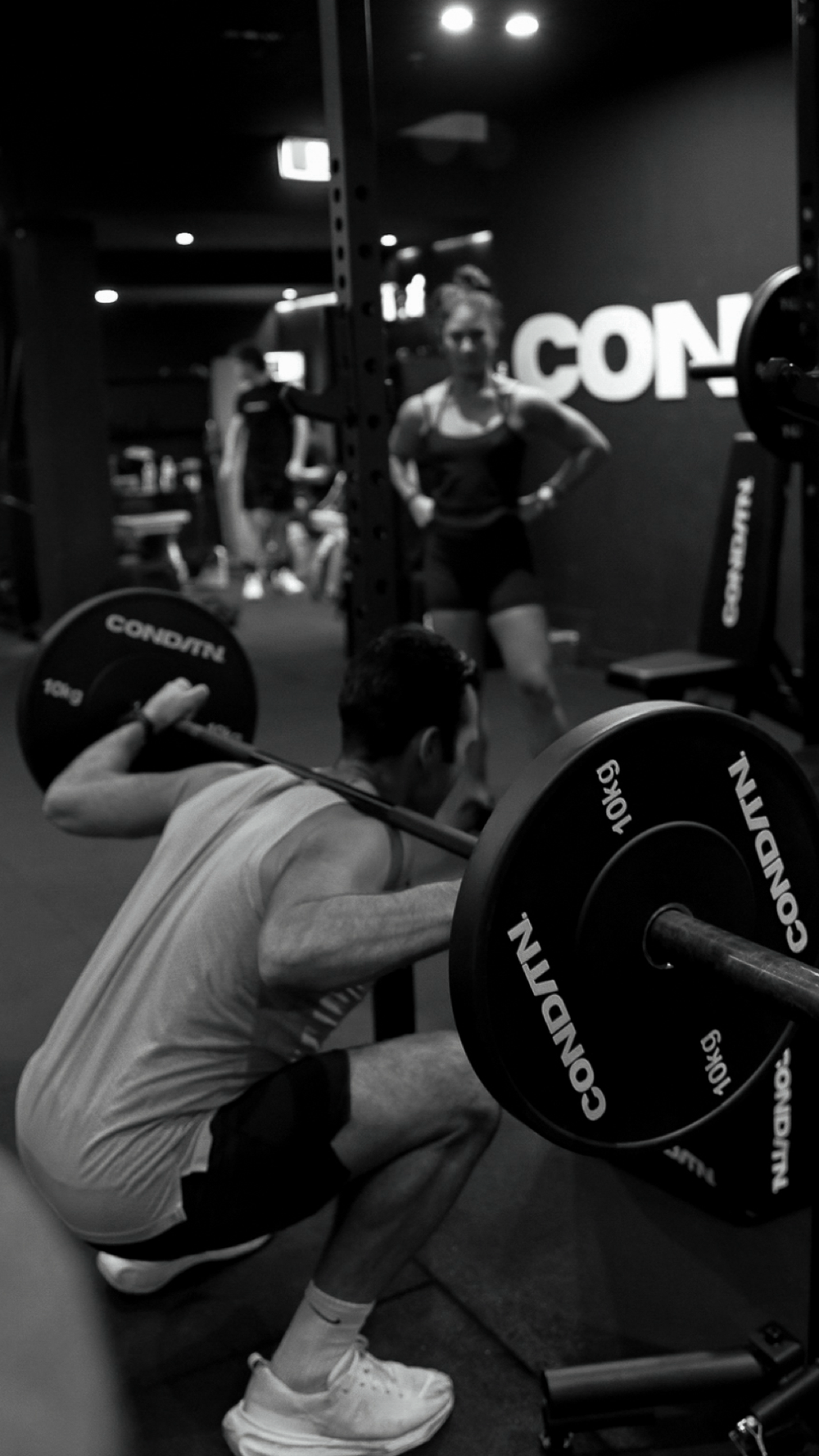 LIFT. class: member back-squatting with a CONDITN. barbell