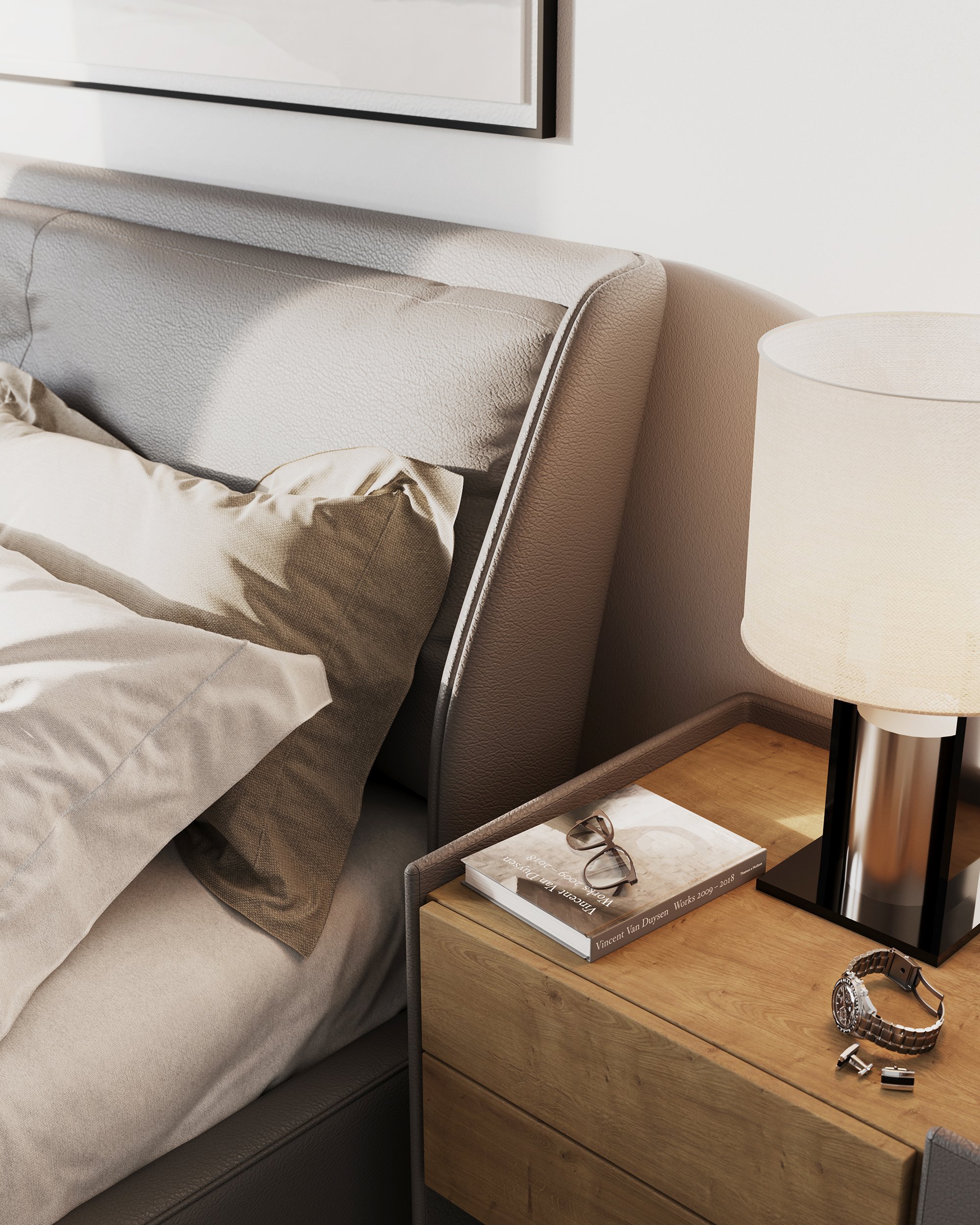 Close-up of a beige upholstered bed with beige pillows, a wooden bedside table, a beige lamp, a magazine, a pair of glasses, a wristwatch, and a pair of earrings.