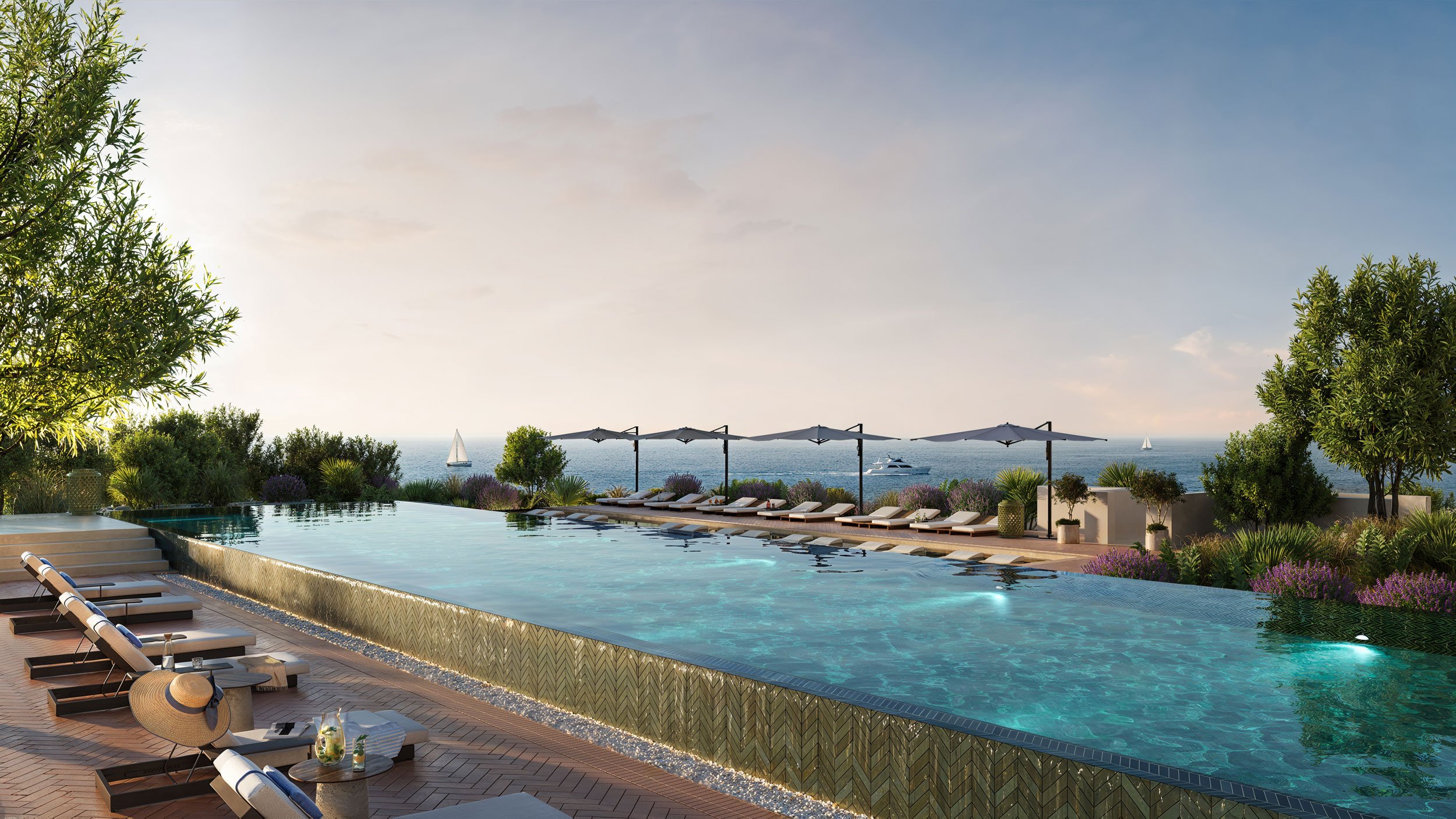 Luxury infinity pool with lounge chairs and umbrellas overlooking the ocean, surrounded by greenery, under a partly cloudy sky.  Beyond Properties. Dubai Real Estate Marketing.