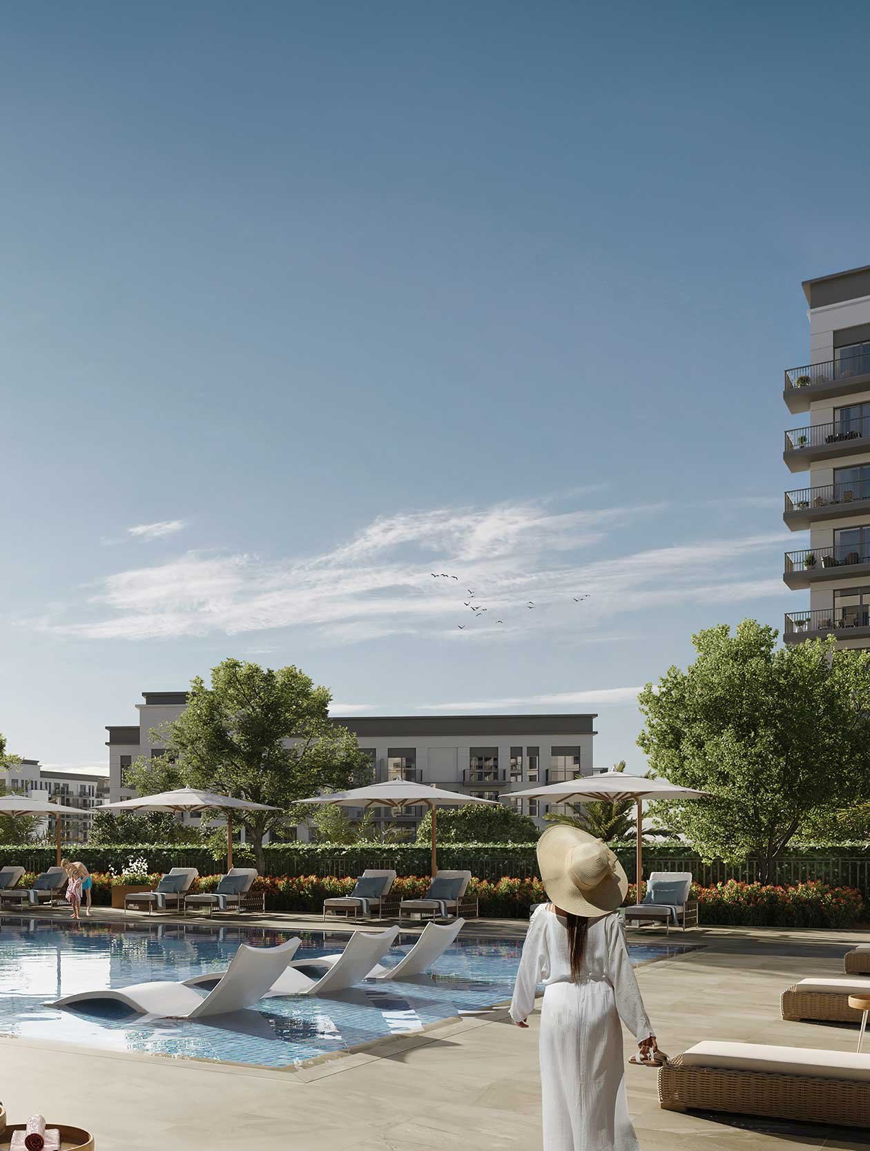 A woman in a white dress and wide-brimmed hat walking beside a swimming pool at a modern apartment complex with lounge chairs, parasols, green trees, and a clear blue sky. Eagle Hills. Maryam Island CGI. Dubai Real estate marketing.
