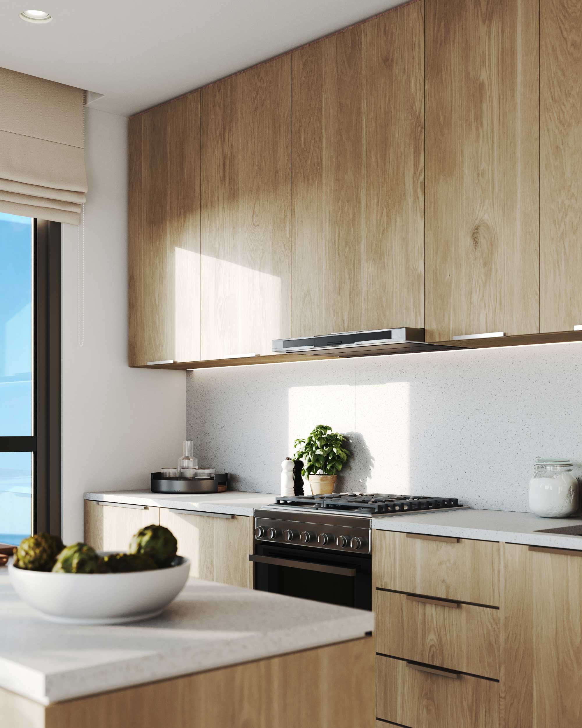Modern kitchen with wooden cabinets, white countertop, stove, potted plant, jar of sugar, and bowl of artichokes.