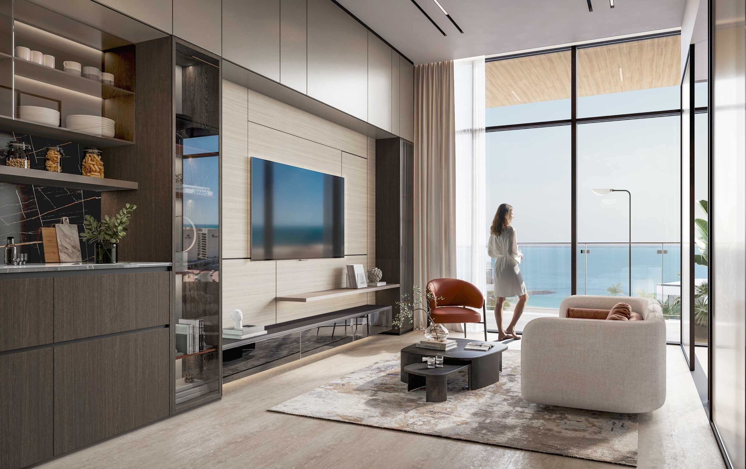Modern living room with large floor-to-ceiling window overlooking the ocean, featuring a woman in a white dress standing near the window, a beige sofa, a red armchair, a black coffee table, and a flat-screen TV on the wall.
