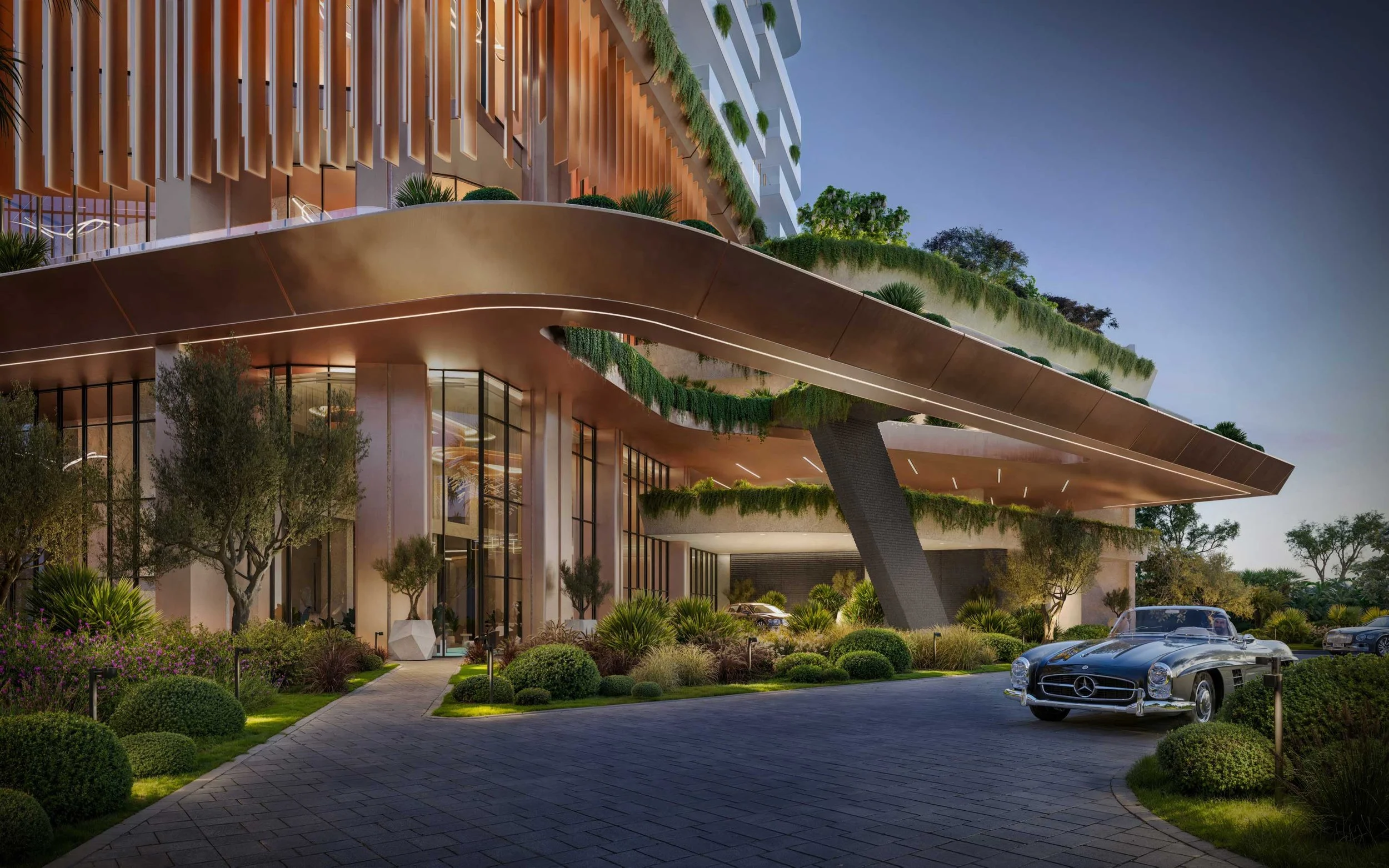 Nighttime view of a modern luxury building with curved architectural design, lush landscaping with trees and bushes, and a vintage black Mercedes-Benz car parked outside.  Beyond Properties. Dubai Real Estate Marketing.