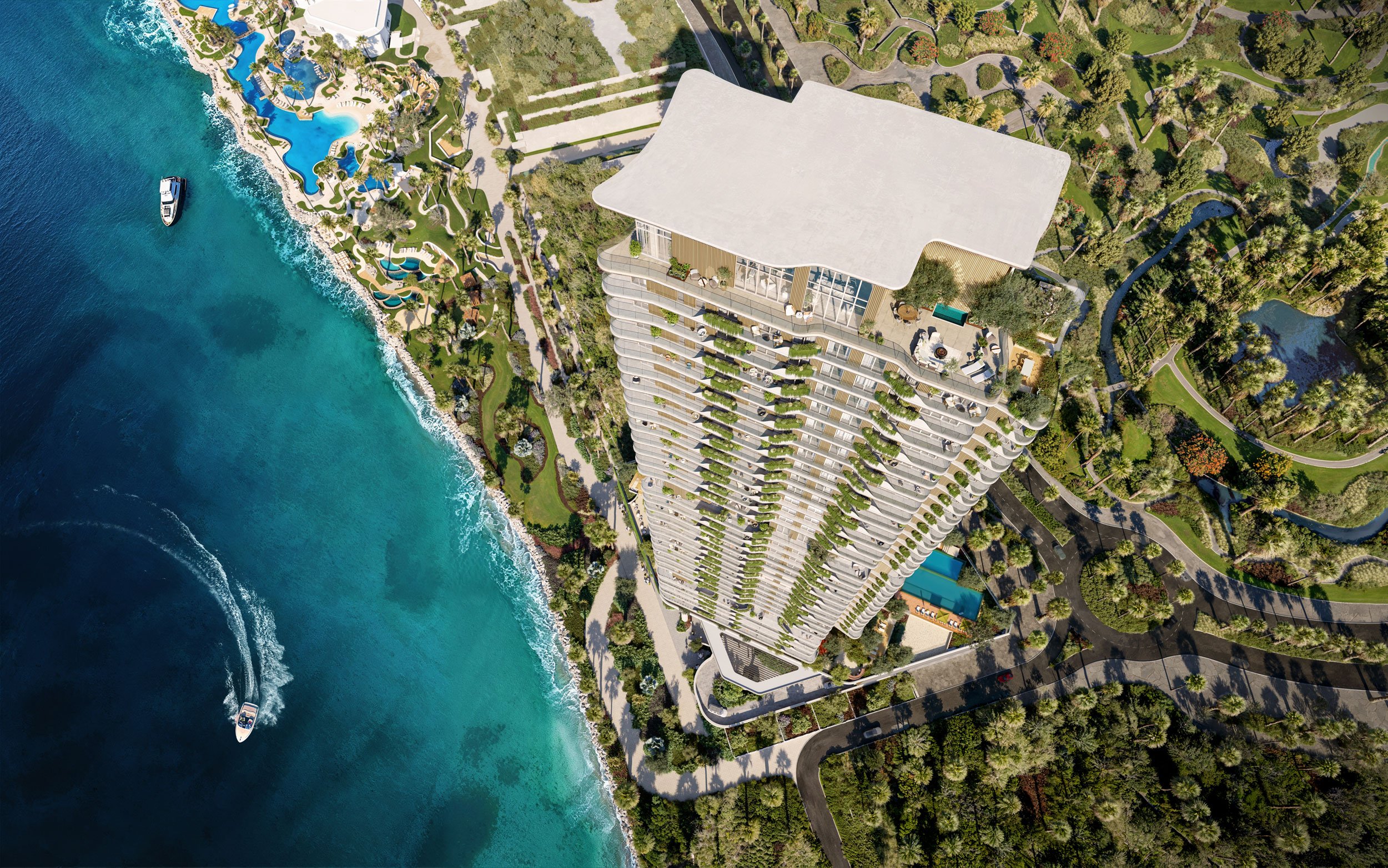 An aerial view of a high-rise building near the ocean with boats in the water and surrounding landscaped green areas.  Beyond Properties. Dubai Real Estate Marketing.