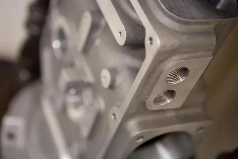 Close-up of a metal breaking component with two threaded ports.