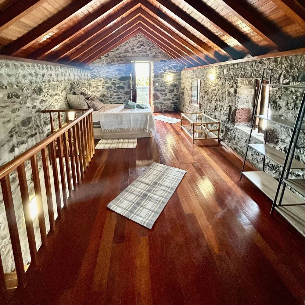 The whole loft from the stairhead, hardwood floor running to the bed