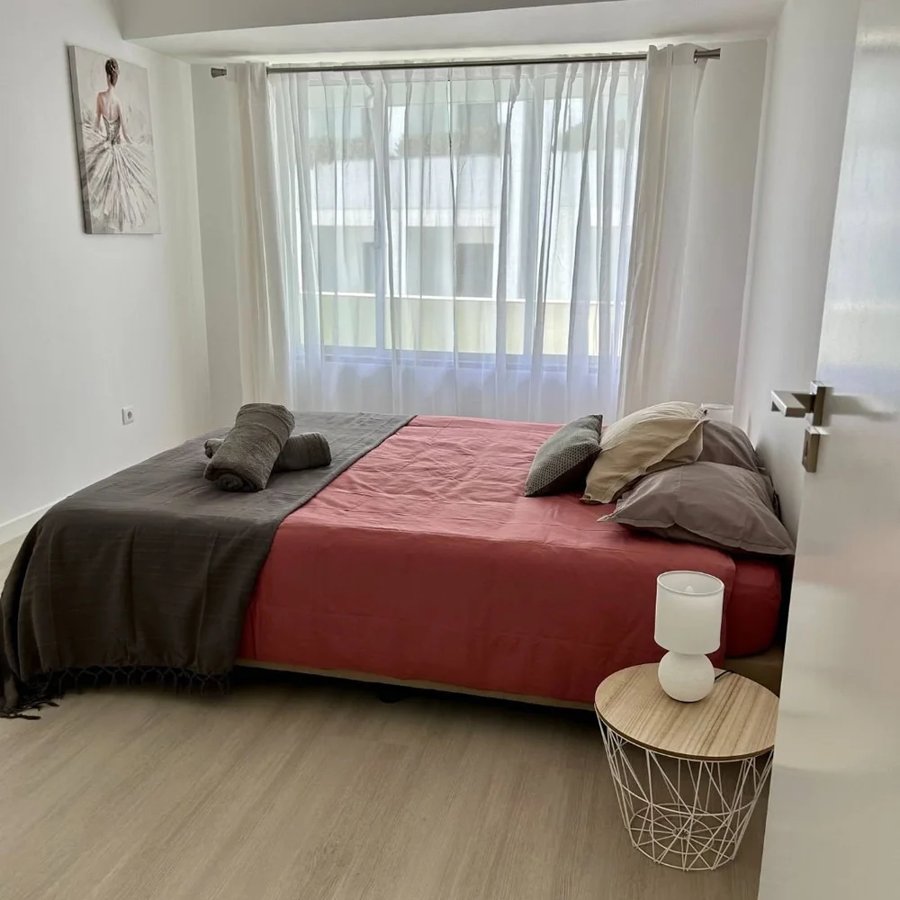 Bedroom with a double bed under a coral cover