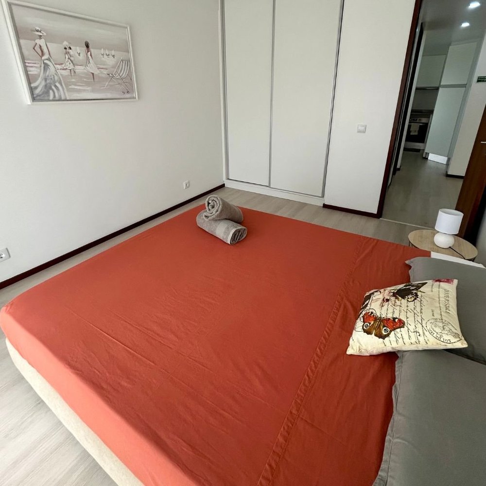 Second bedroom with fitted wardrobes and a rust cover on the bed