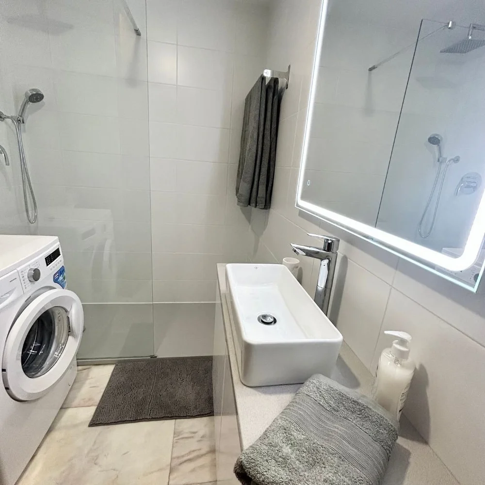 Bathroom with a walk-in shower, a vessel basin and the washing machine
