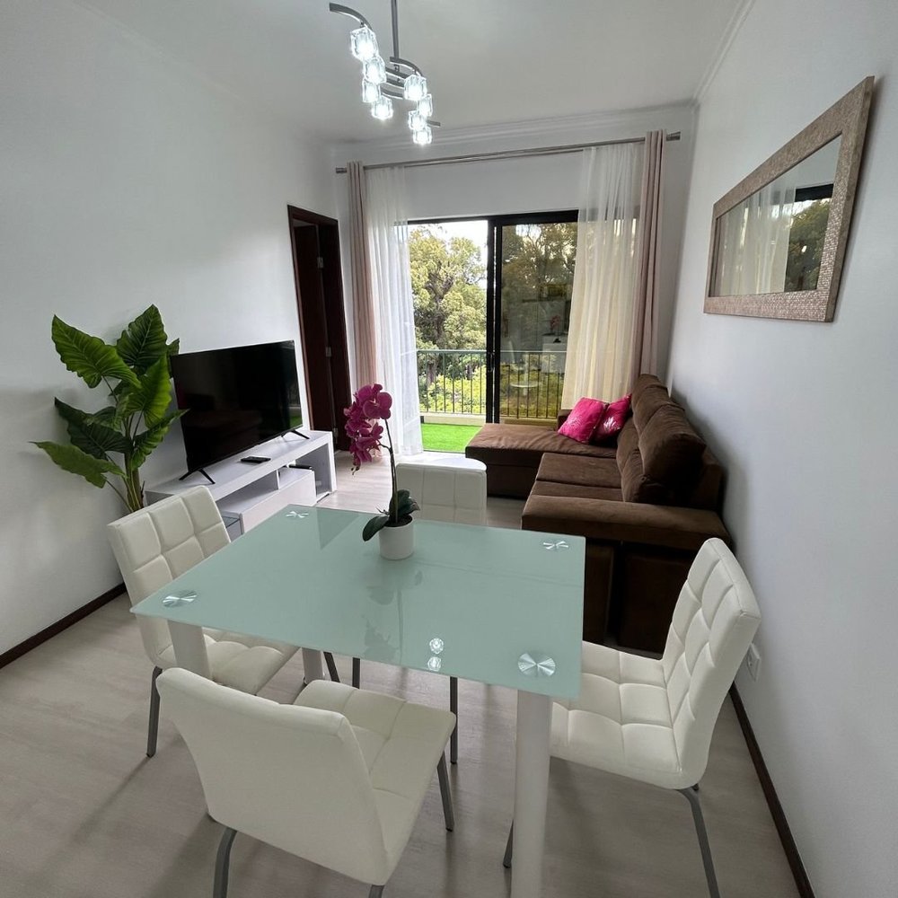 The living room from the far end with the television and the balcony doors