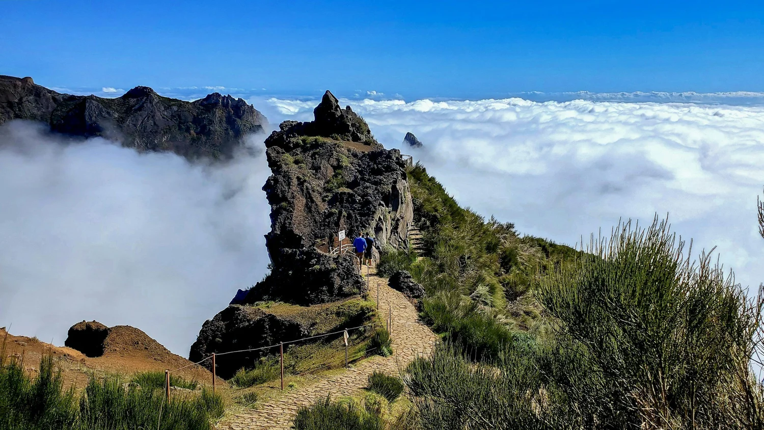 A hiker on a Madeira mountain ridge above the cloud layer
