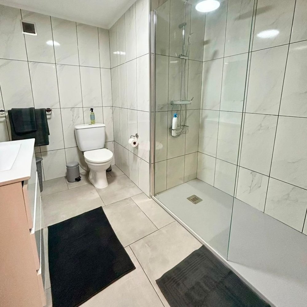 A shower room in marbled tile with a large walk-in shower