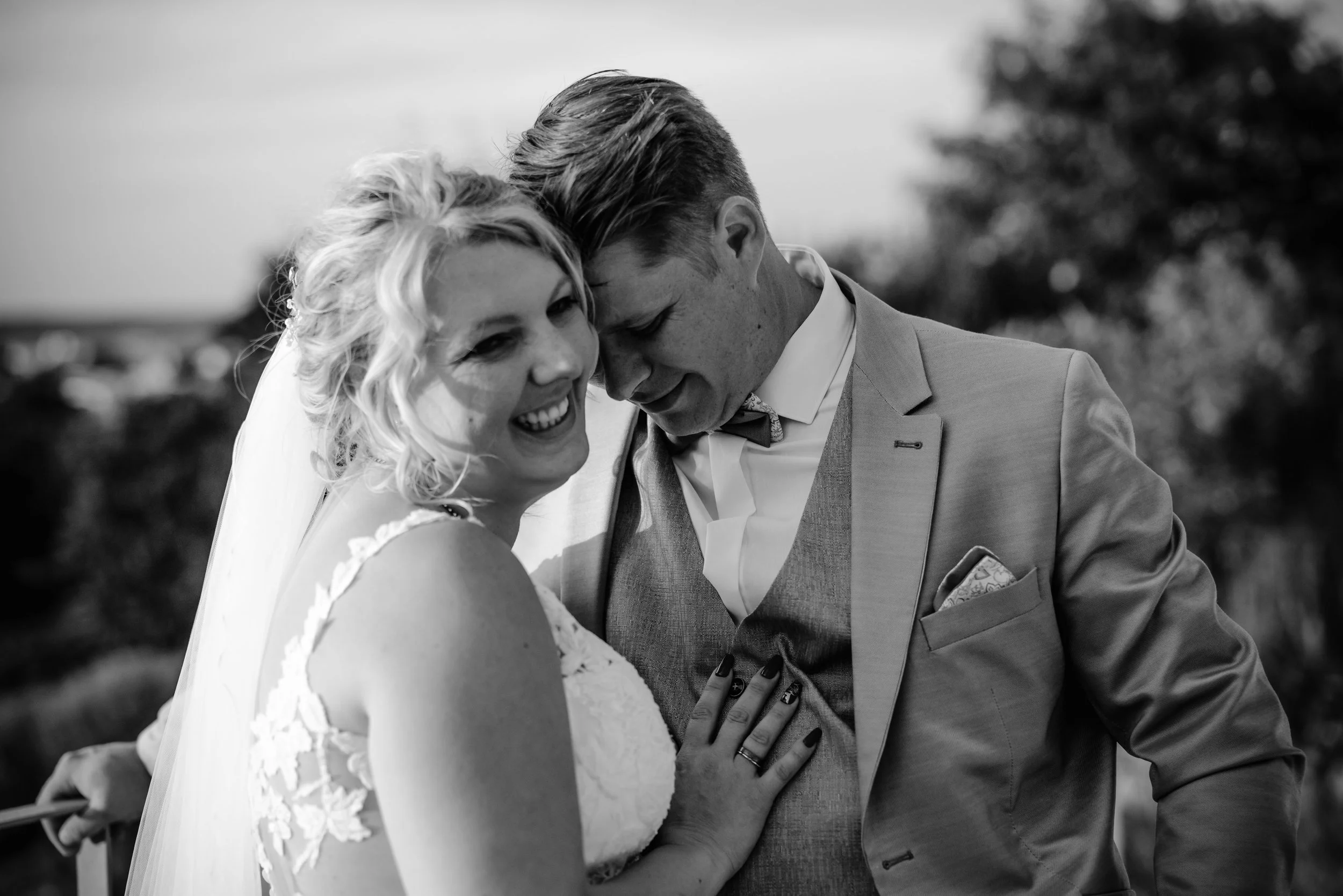 Ein lachendes Brautpaar bei ihrer Hochzeit, Schwarz-Weiß-Foto