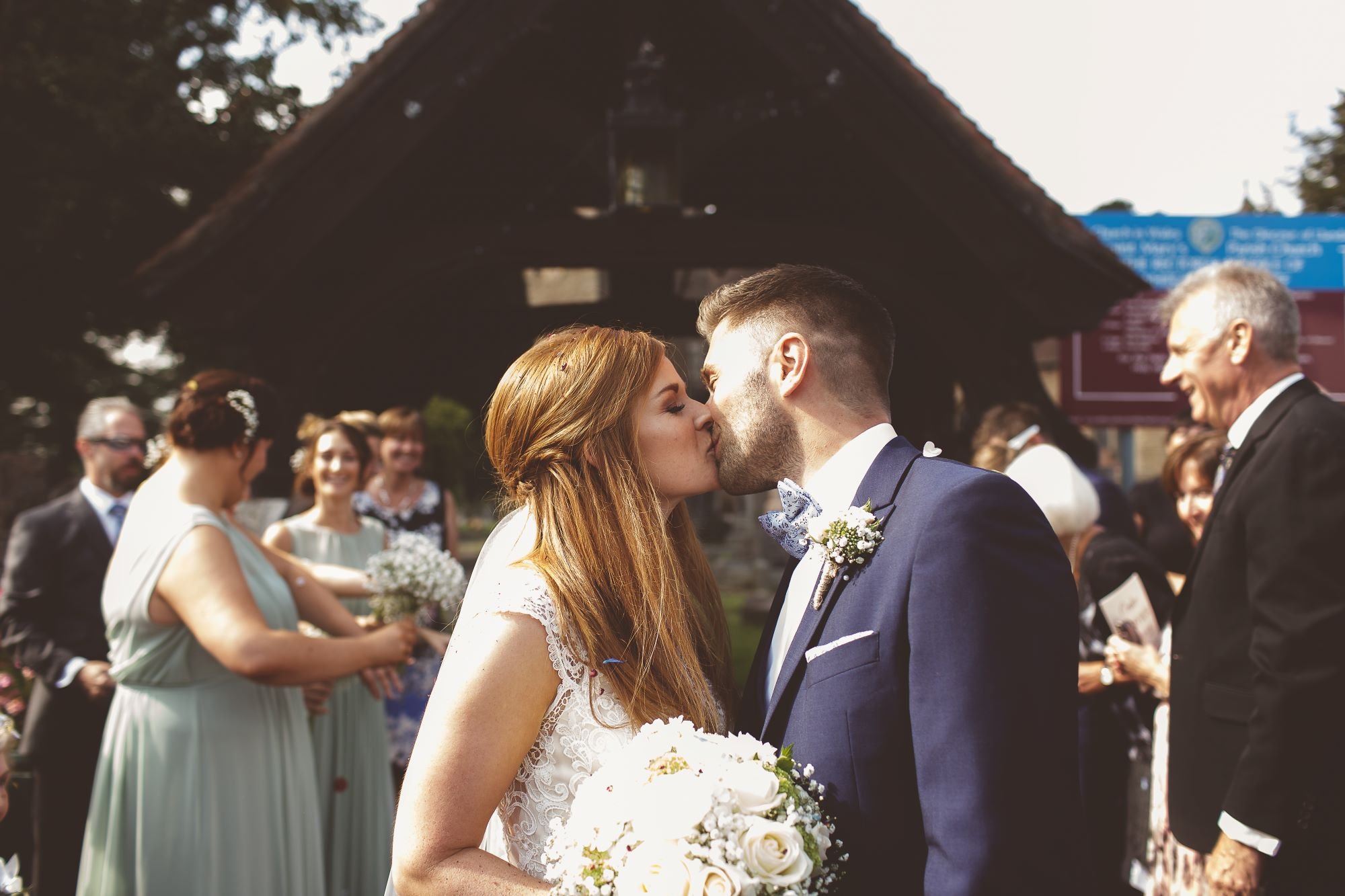 Bride and groom kissing outside church