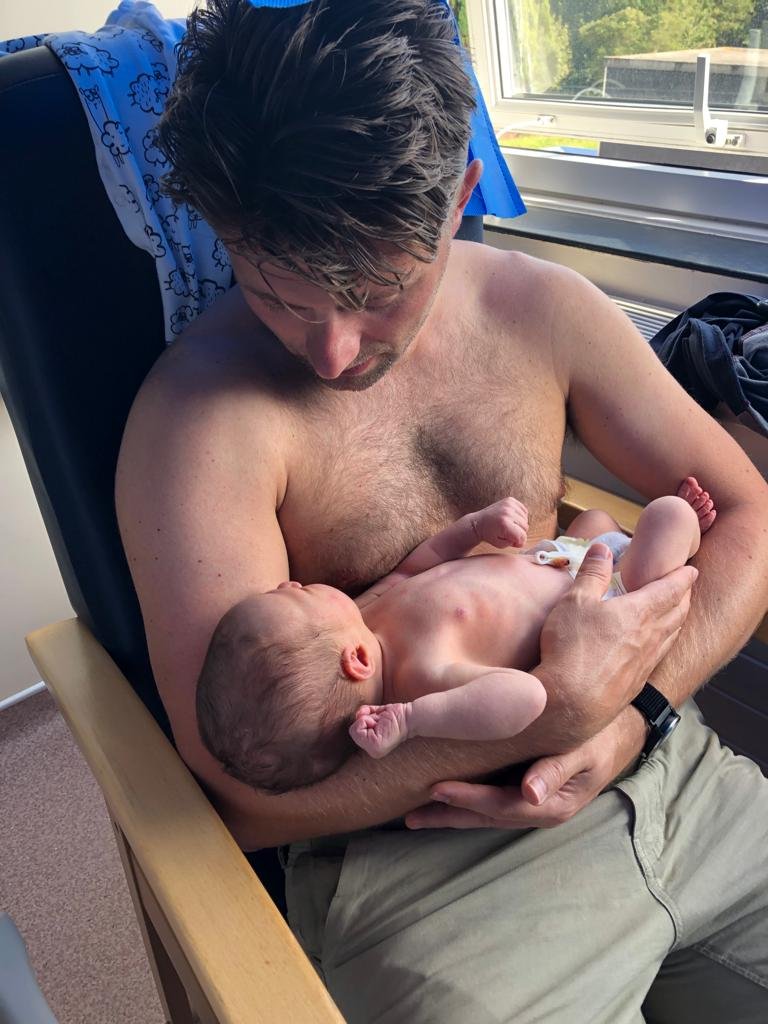 Newborn baby being held by father