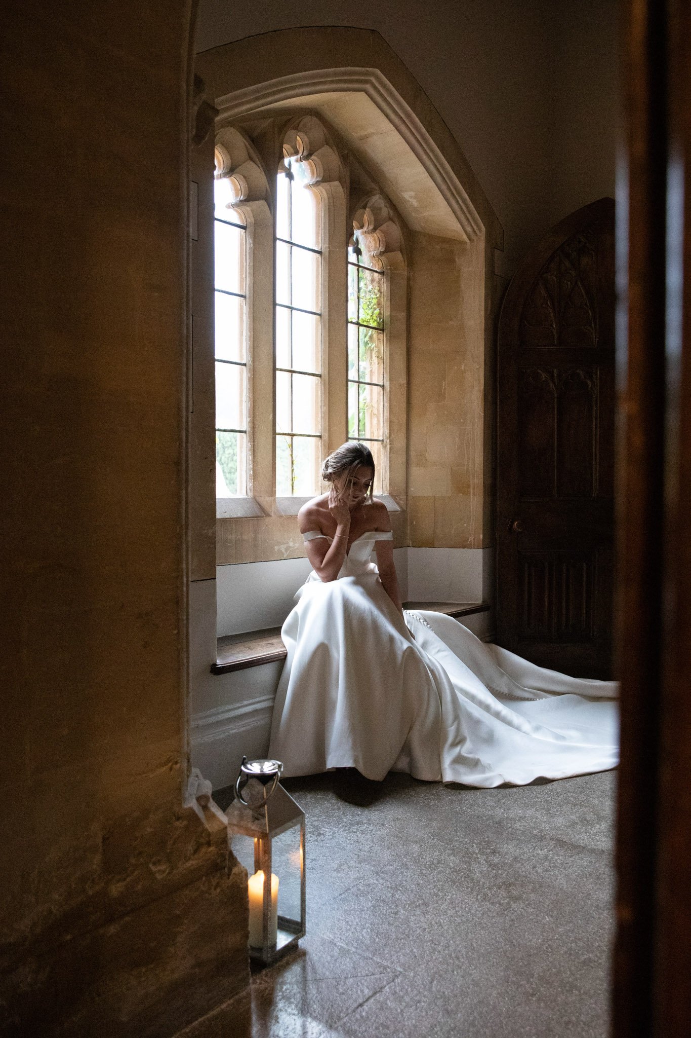 bride posing for photos at St Audries Park in window, looking away from the camera