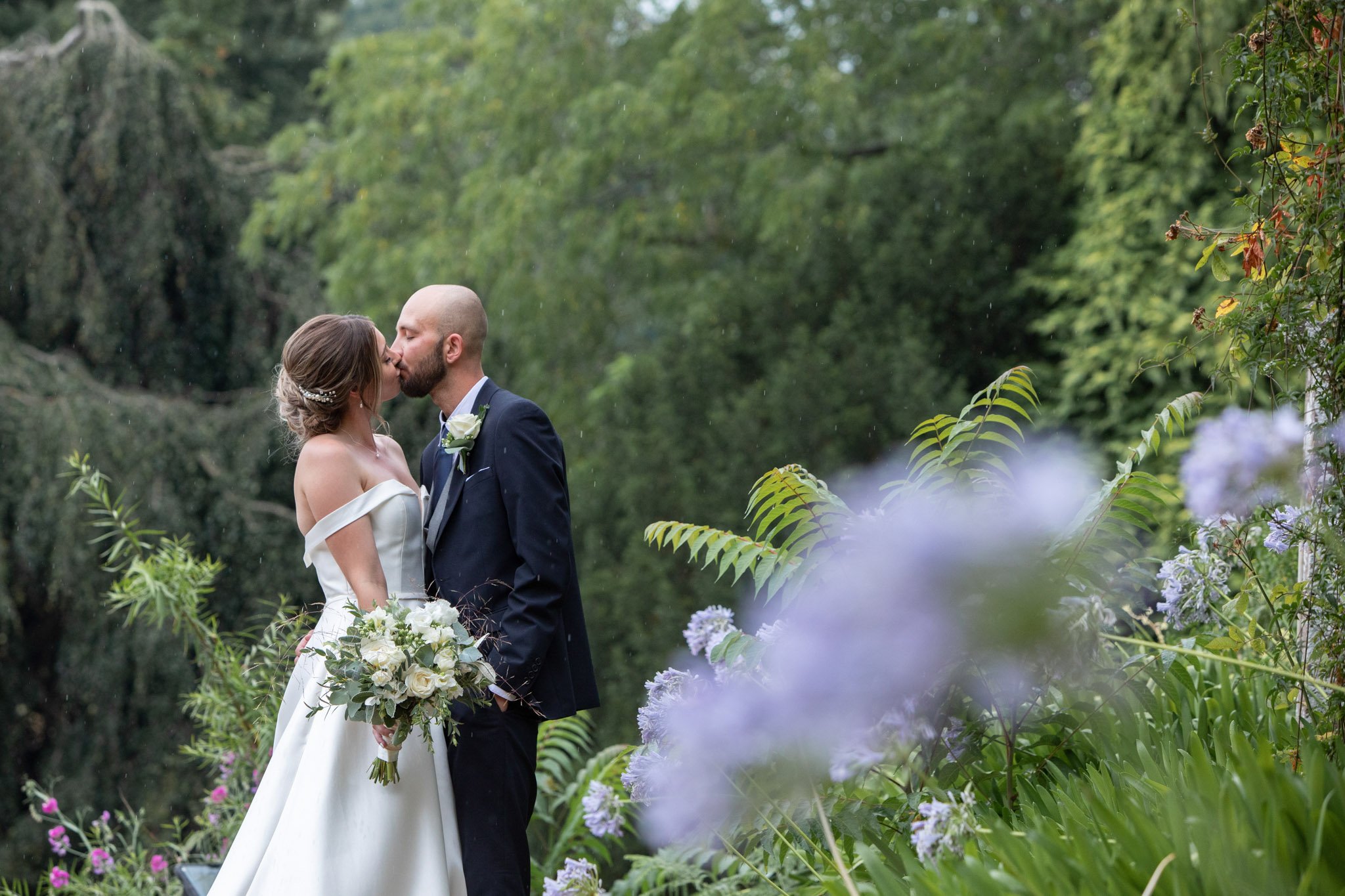 Couple kissing in wedding venue grounds, St Audries Park