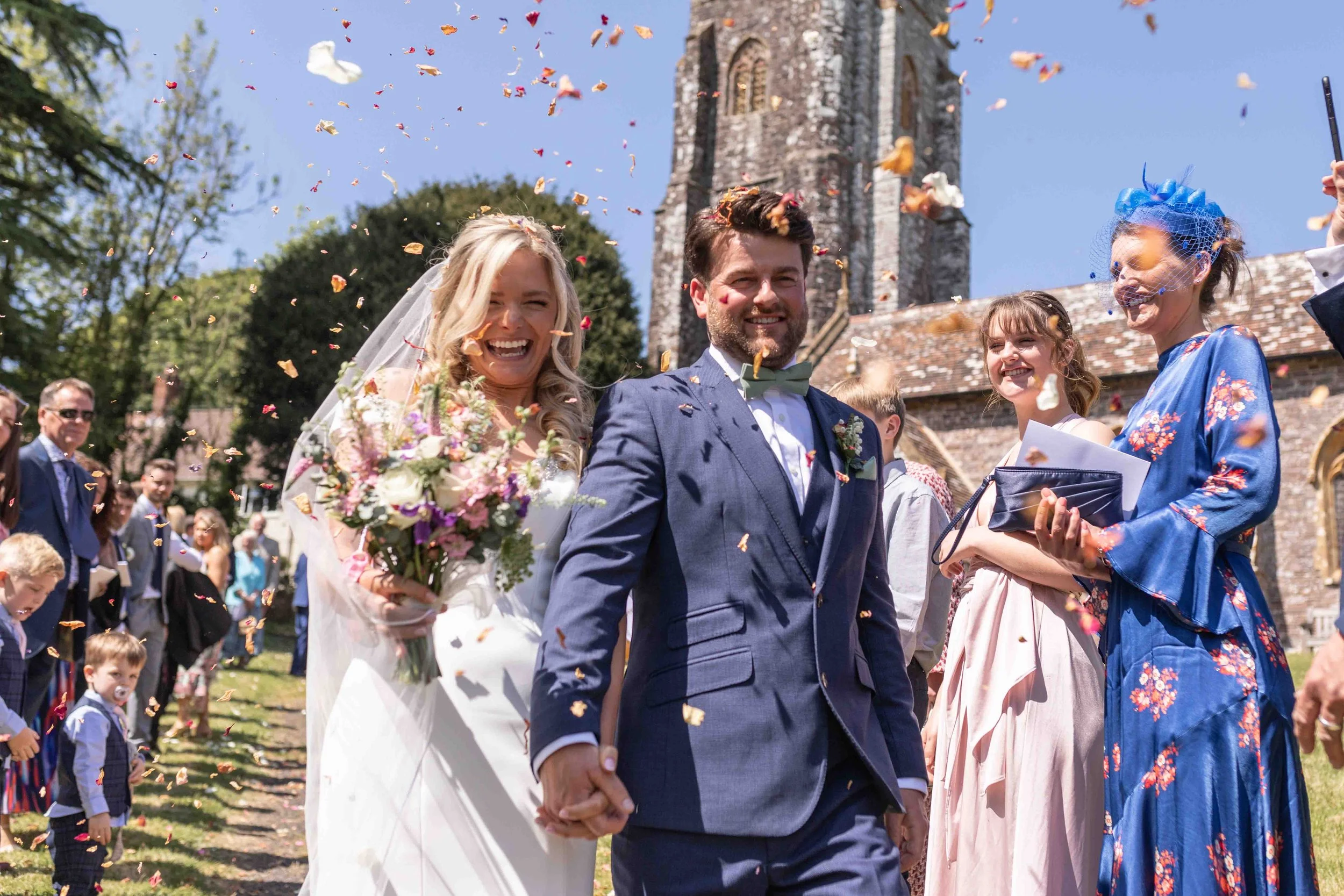 Zoe & Rupert walking through their confetti line