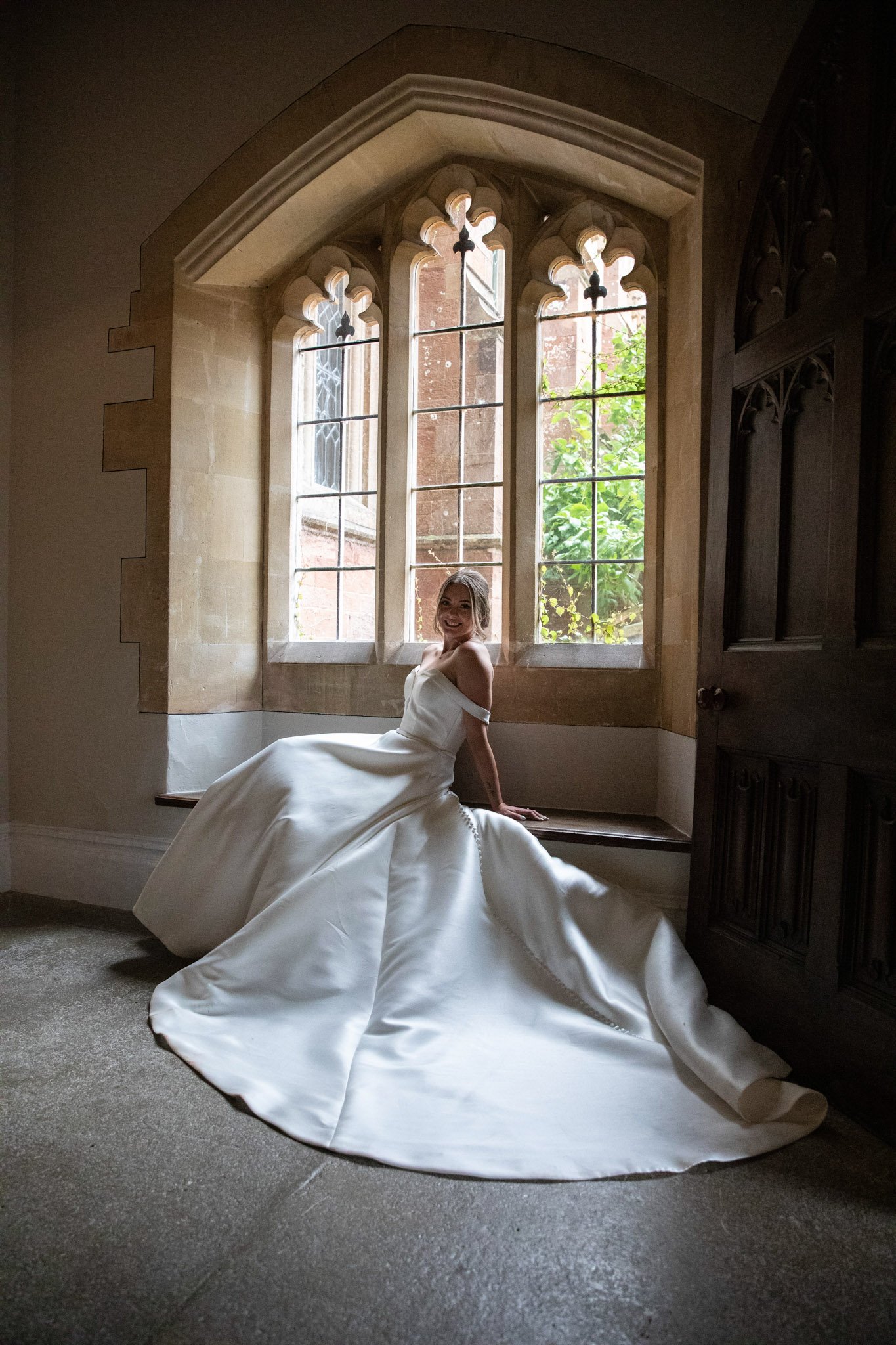 bride posing for photos at St Audries Park in window