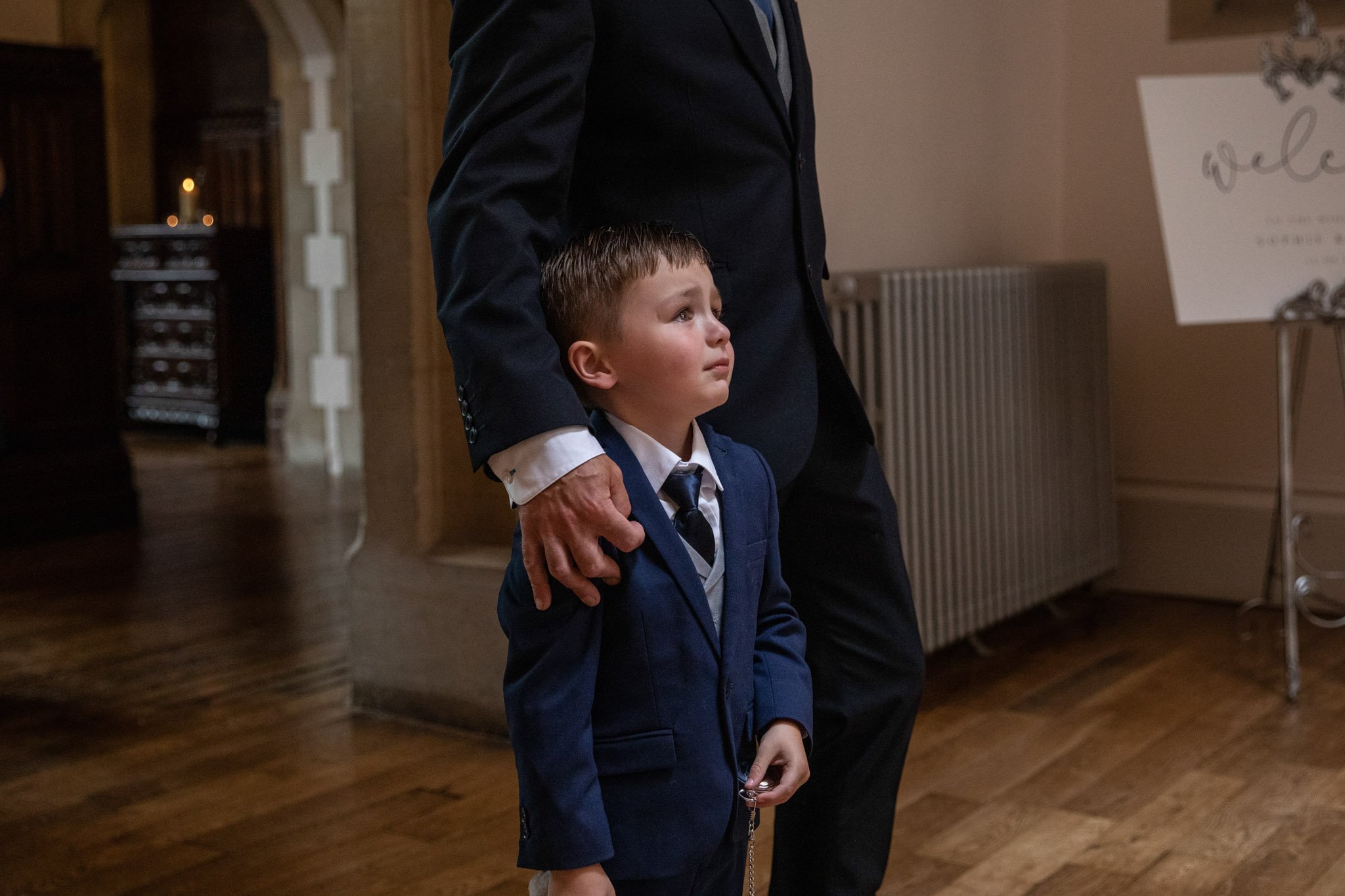 Young boy stood with man at a wedding