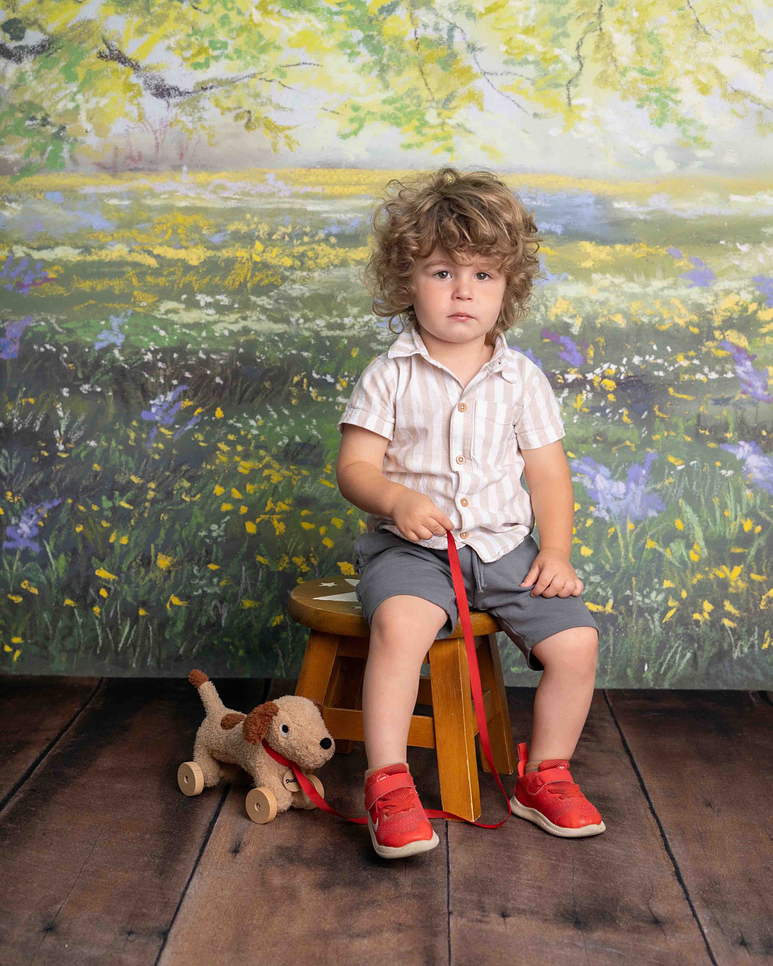 child on stool with toy dog