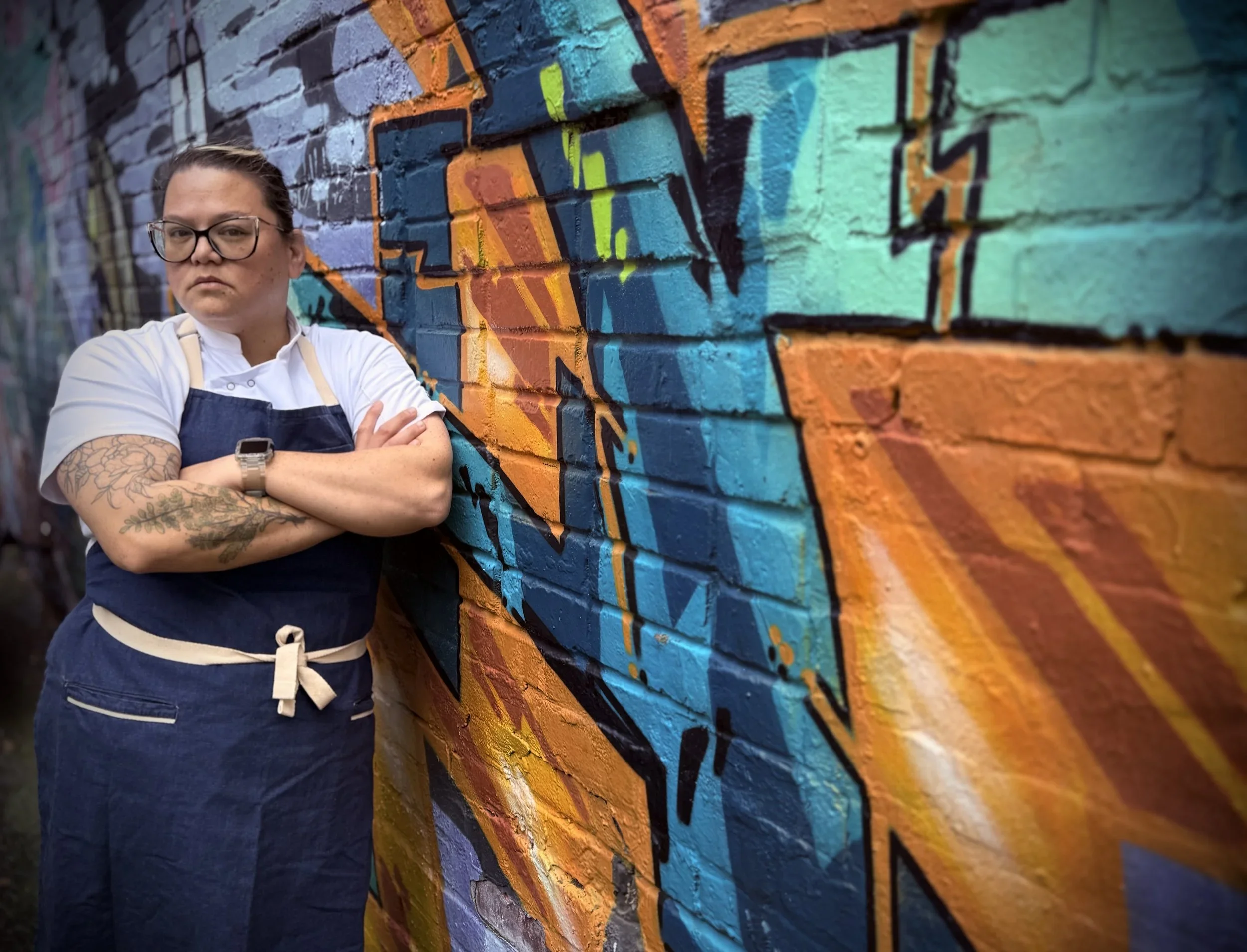 Chef Katie standing near a painted mural