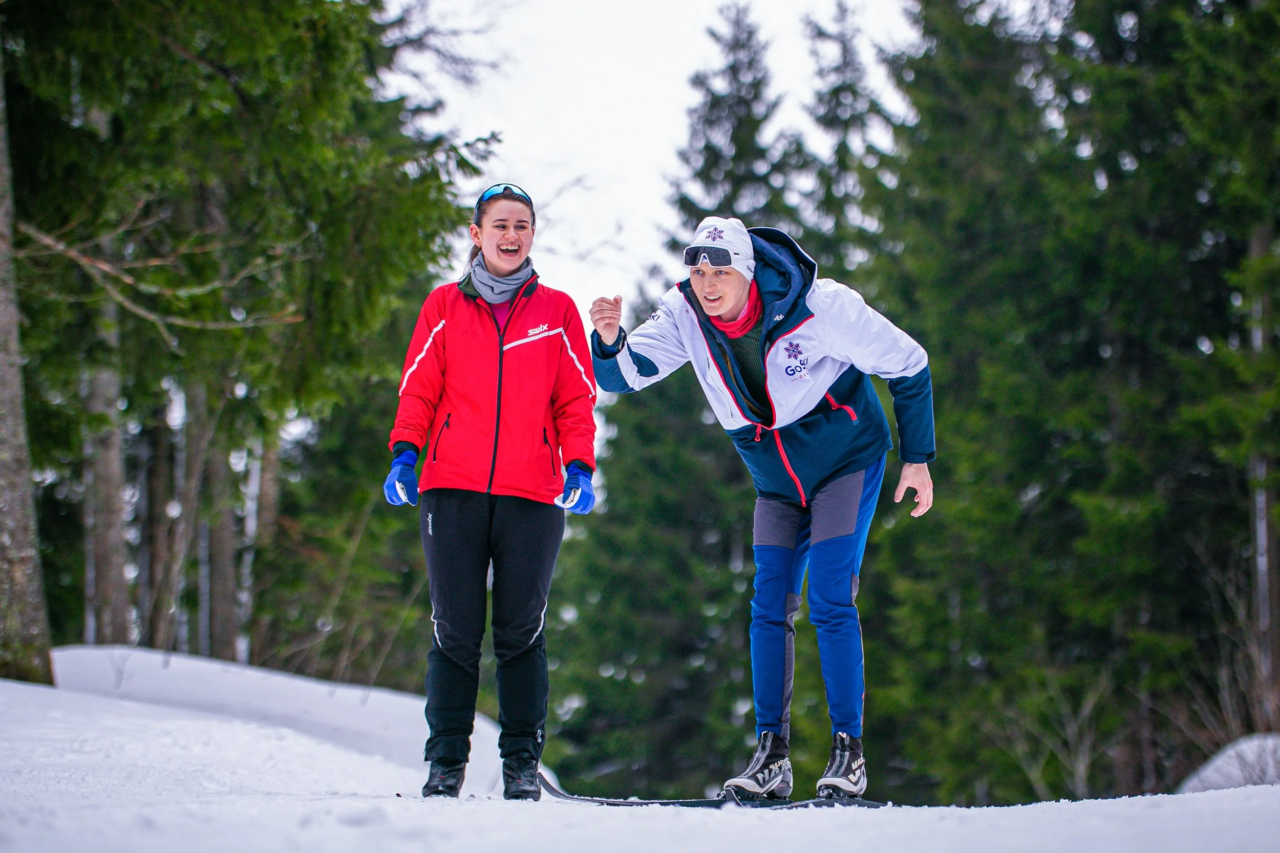 Ski instructor explaining the basic classic ski technique to participant in a funny way