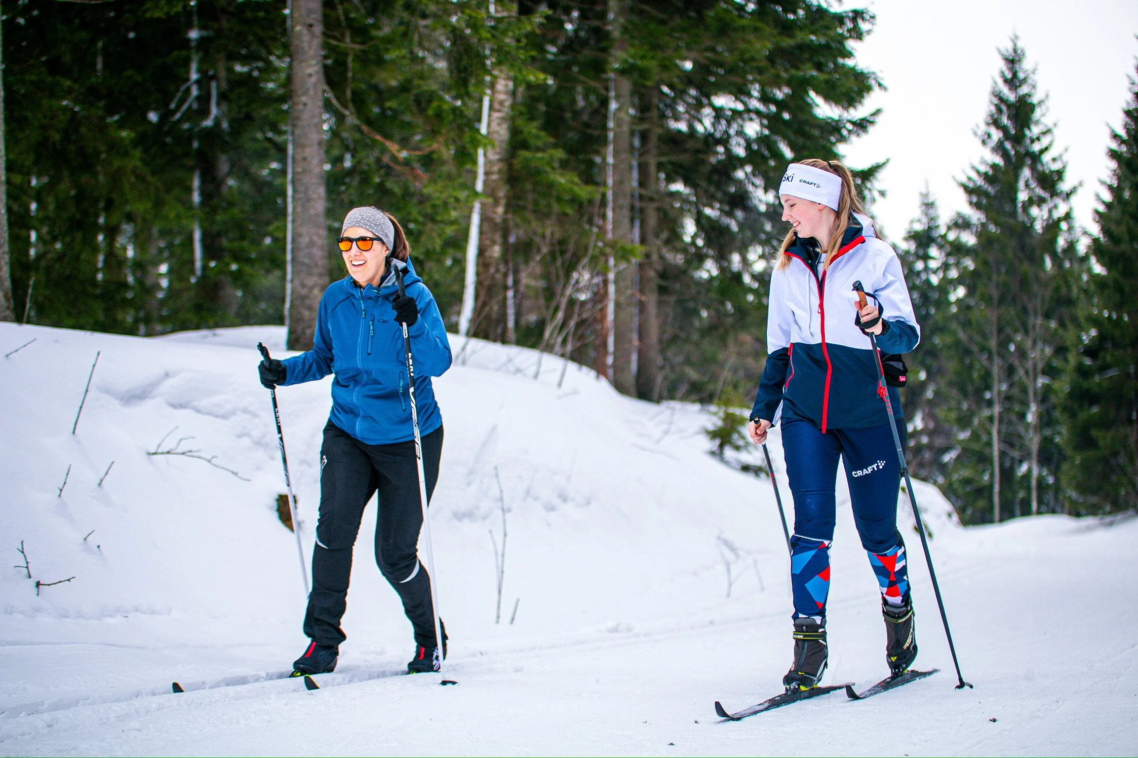 Tourist learning classic cross-country skiing with an instructor in a snowy Norwegian forest