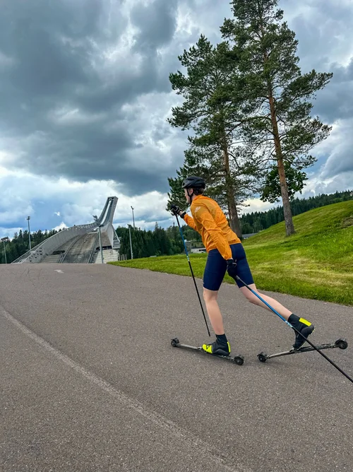 Instruktør viser klassisk teknikk på rulleski ved Holmenkollen
