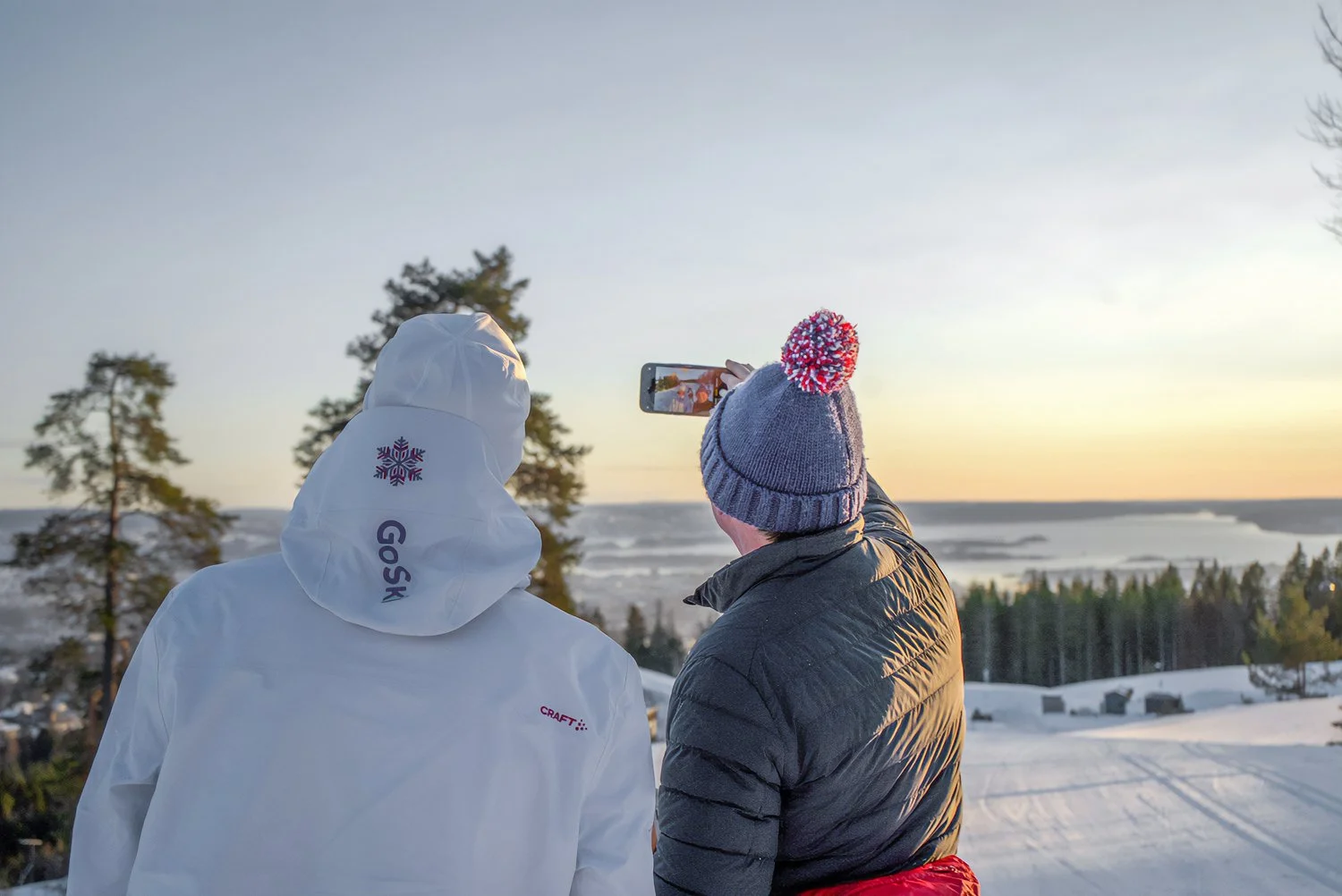 Male participant and instructor take photoshoot after ski tour