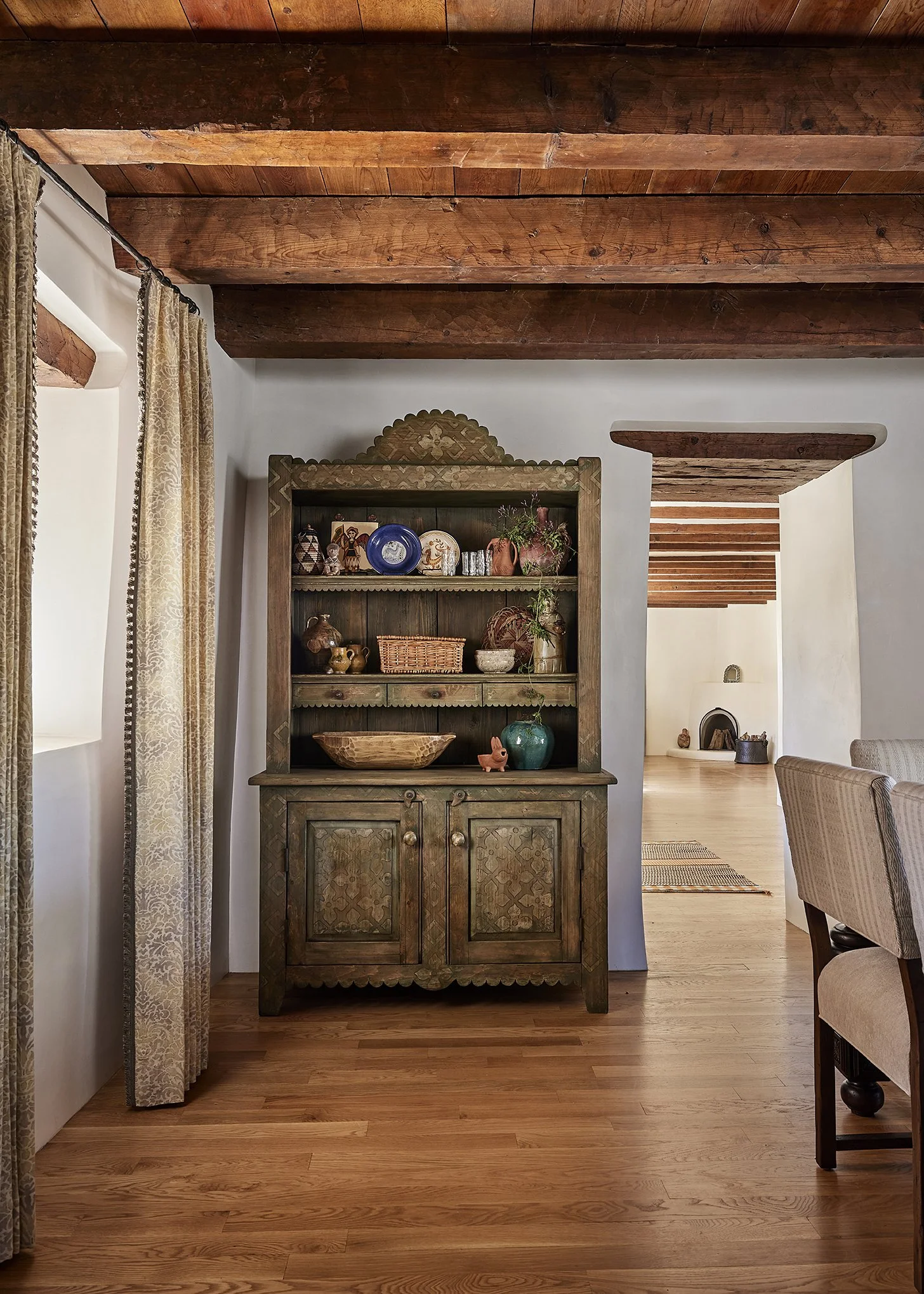 Rustic green hutch at Applegate Estate styled with ceramics, woven baskets, and pottery, highlighting handcrafted Southwestern details and traditional design.