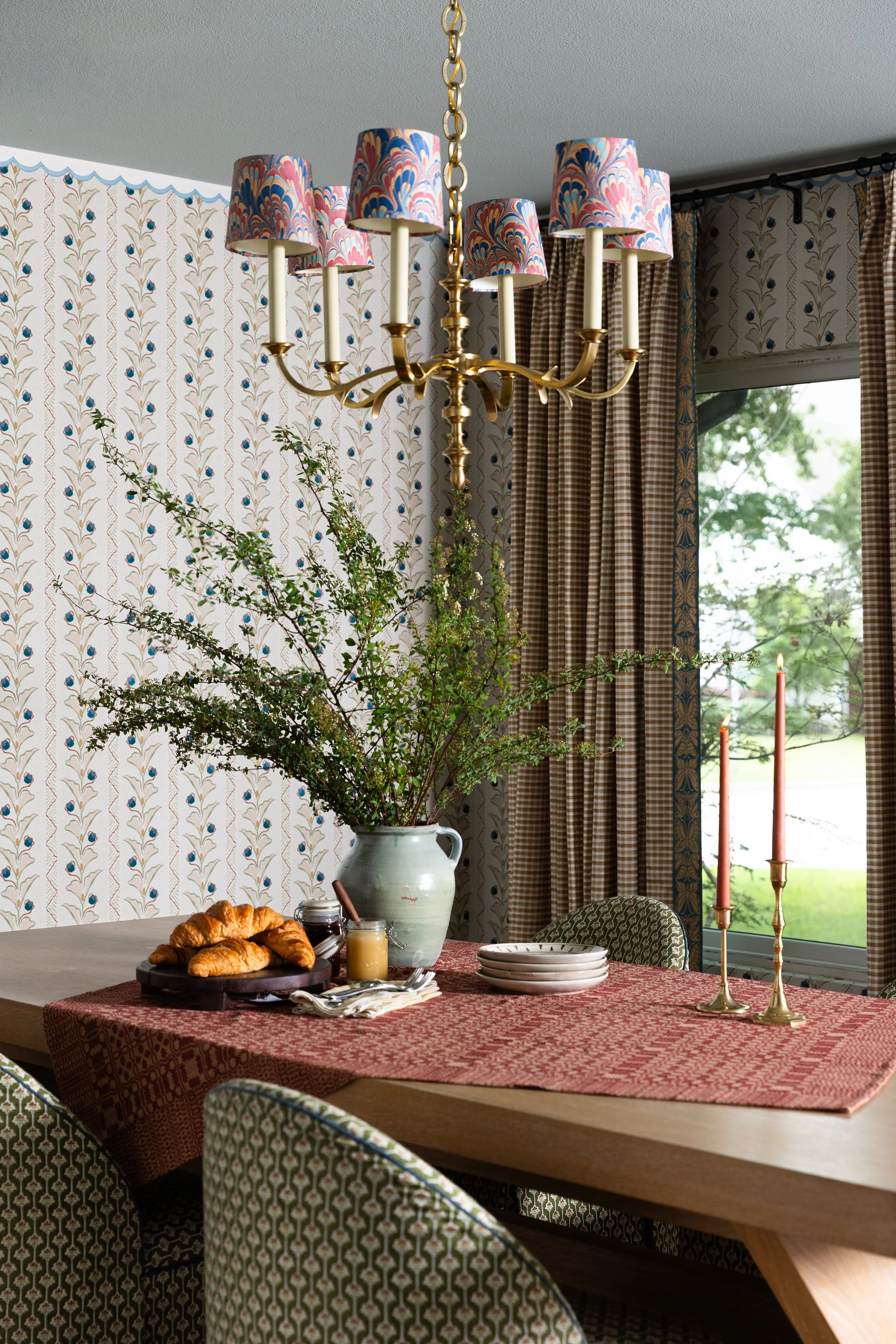 A brass chandelier dressed in hand-marbled shades becomes the centerpiece of this Dallas dining room - the kind of detail that transforms a familiar space into something entirely its own.