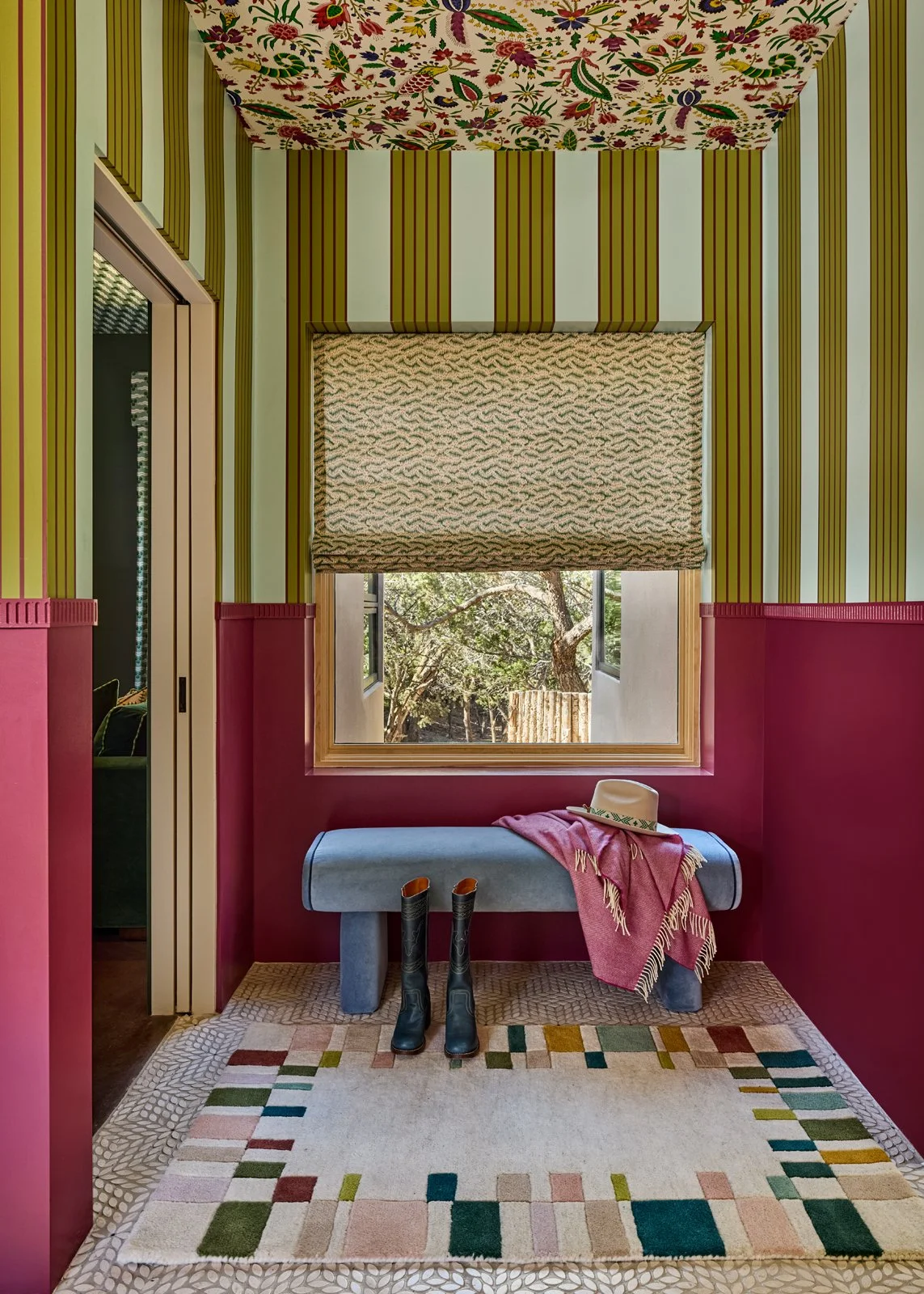 A thoughtfully designed Santa Fe interior vignette featuring custom window treatments, a tailored bench, and a geometric wool rug. This space highlights layered color, artisan textiles, and the studio’s signature approach to curated maximalism.
