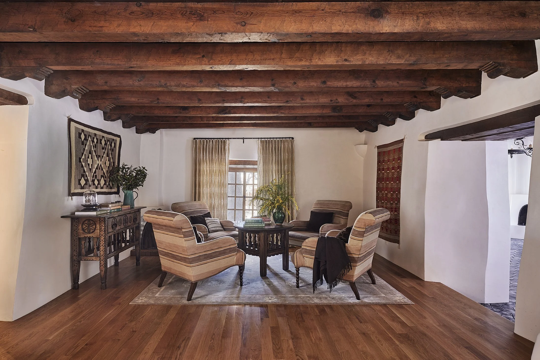 Applegate Estate living room with exposed wooden ceiling beams, layered neutral seating, and Southwestern textiles, designed by French & French Interiors.