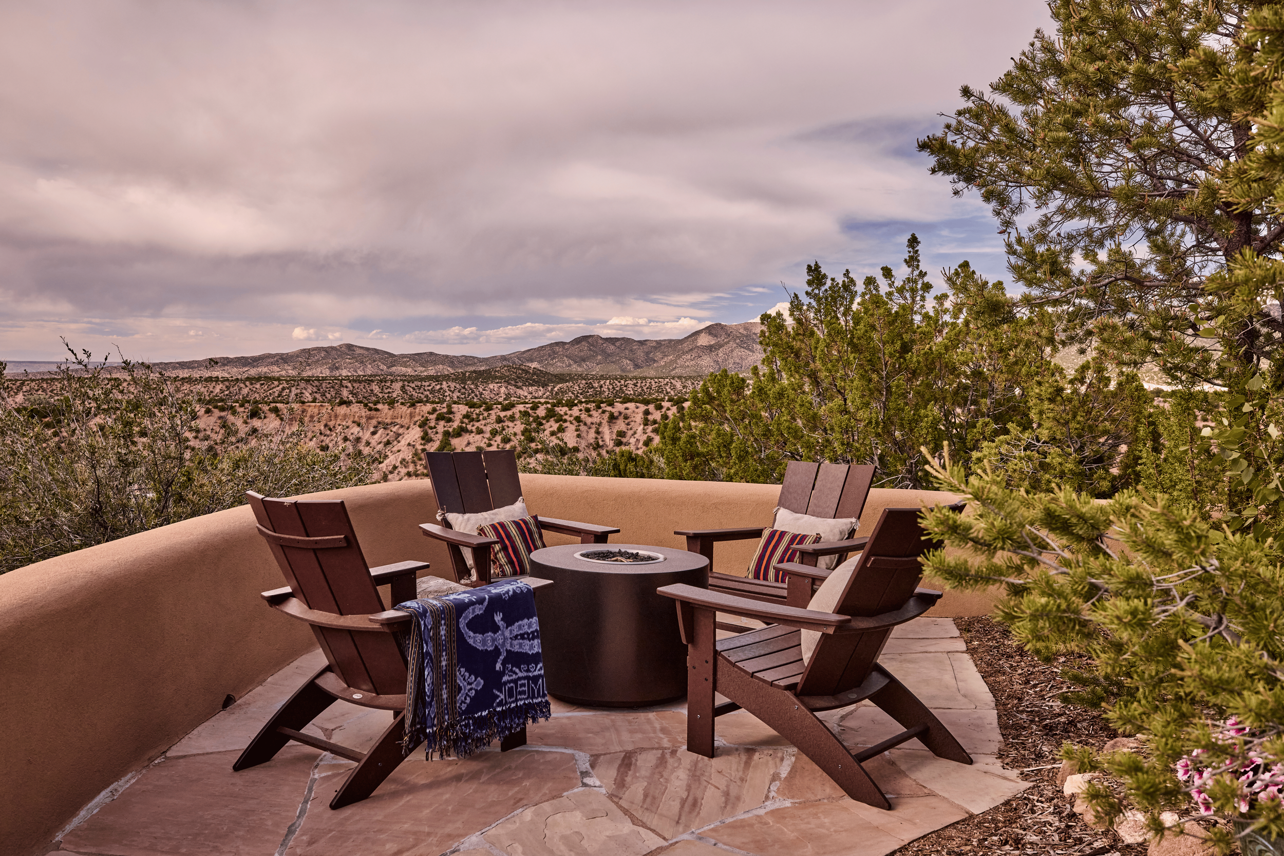 The fire pit terrace at the Mesa Project faces the Sangre de Cristo Mountains without obstruction - a view French & French Interiors treated as a design element in its own right, letting the landscape anchor the entire outdoor living space.