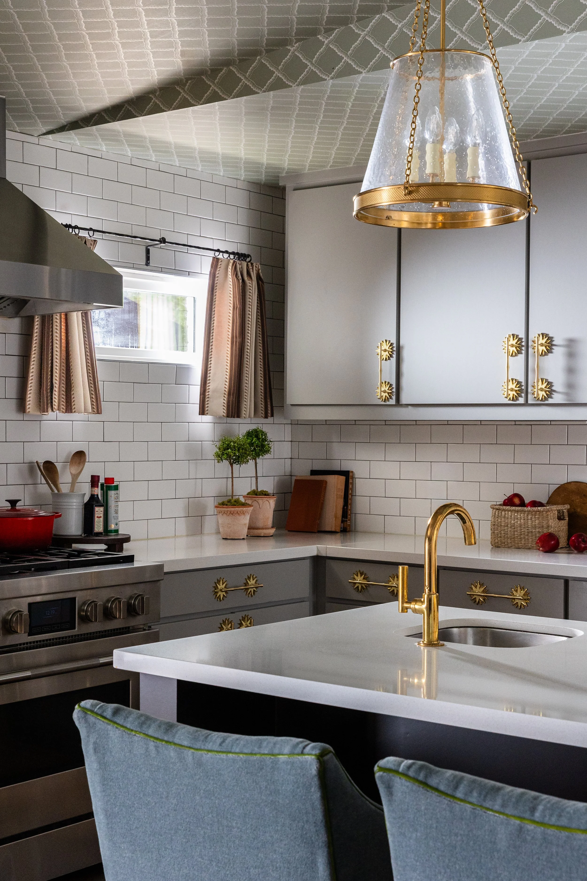Brass starburst hardware and a gooseneck faucet bring artisan detail to the kitchen in this Dallas cottage home - proof that the smallest choices carry the most character.