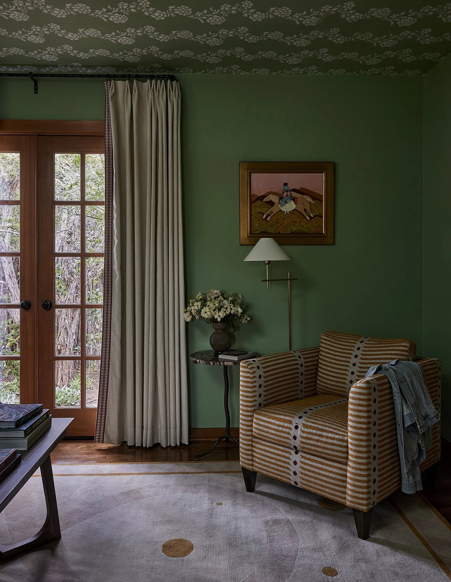 Sitting area with patterned armchair and green walls, blending modern comfort with Southwest-inspired luxury interior design.