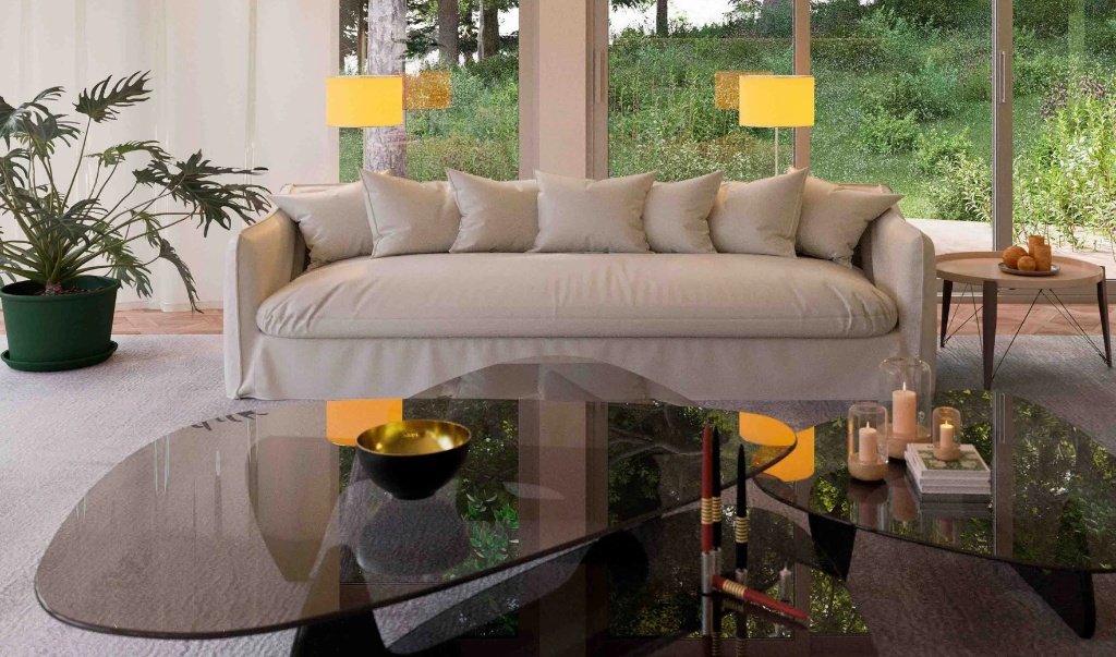 Close-up of a luxury living room in Girona featuring a minimalist beige sofa, smoked glass coffee tables with gold accents, and floor-to-ceiling windows reflecting the forest, designed by Sebastian PM