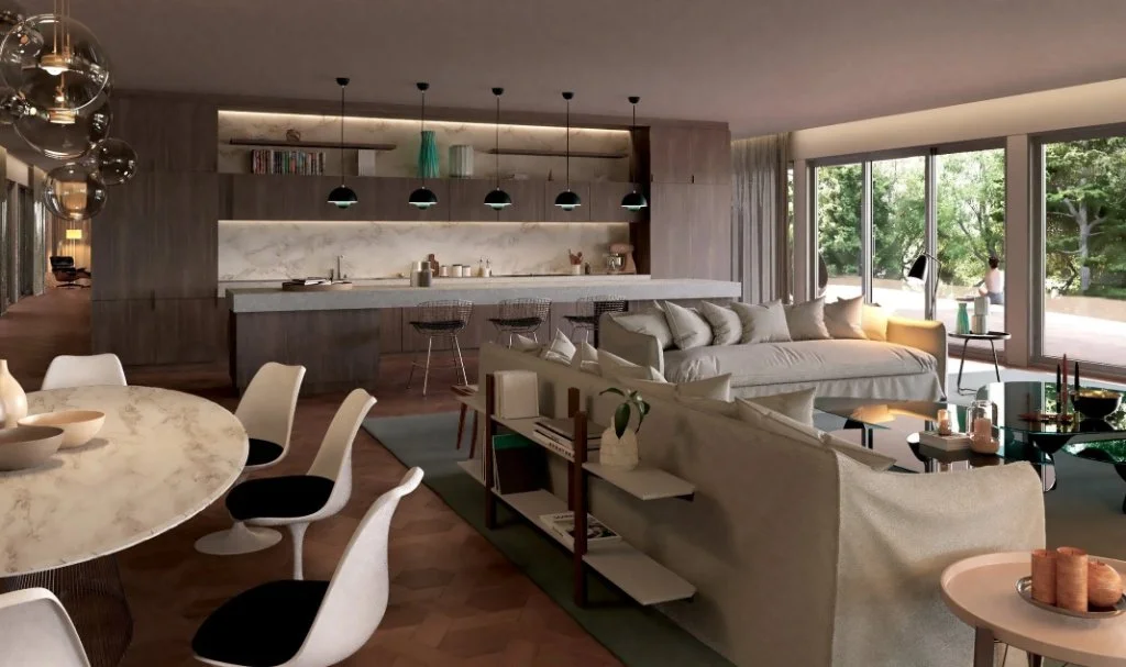 Luxury open-plan interior in Girona featuring a modern kitchen with stone island, dining area with marble table, and a contemporary lounge with forest views through panoramic windows, designed by Sebastian PM.