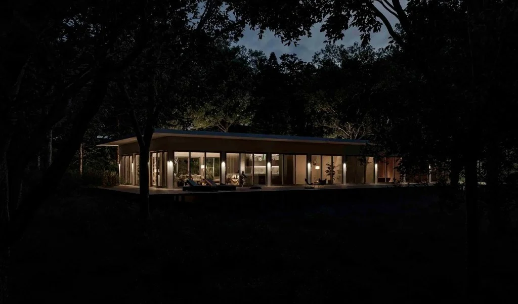 Panoramic night view of a luxury modern residence in Girona, featuring illuminated glass walls, a flat roof design, and a dark forest surroundings, designed by Sebastian PM