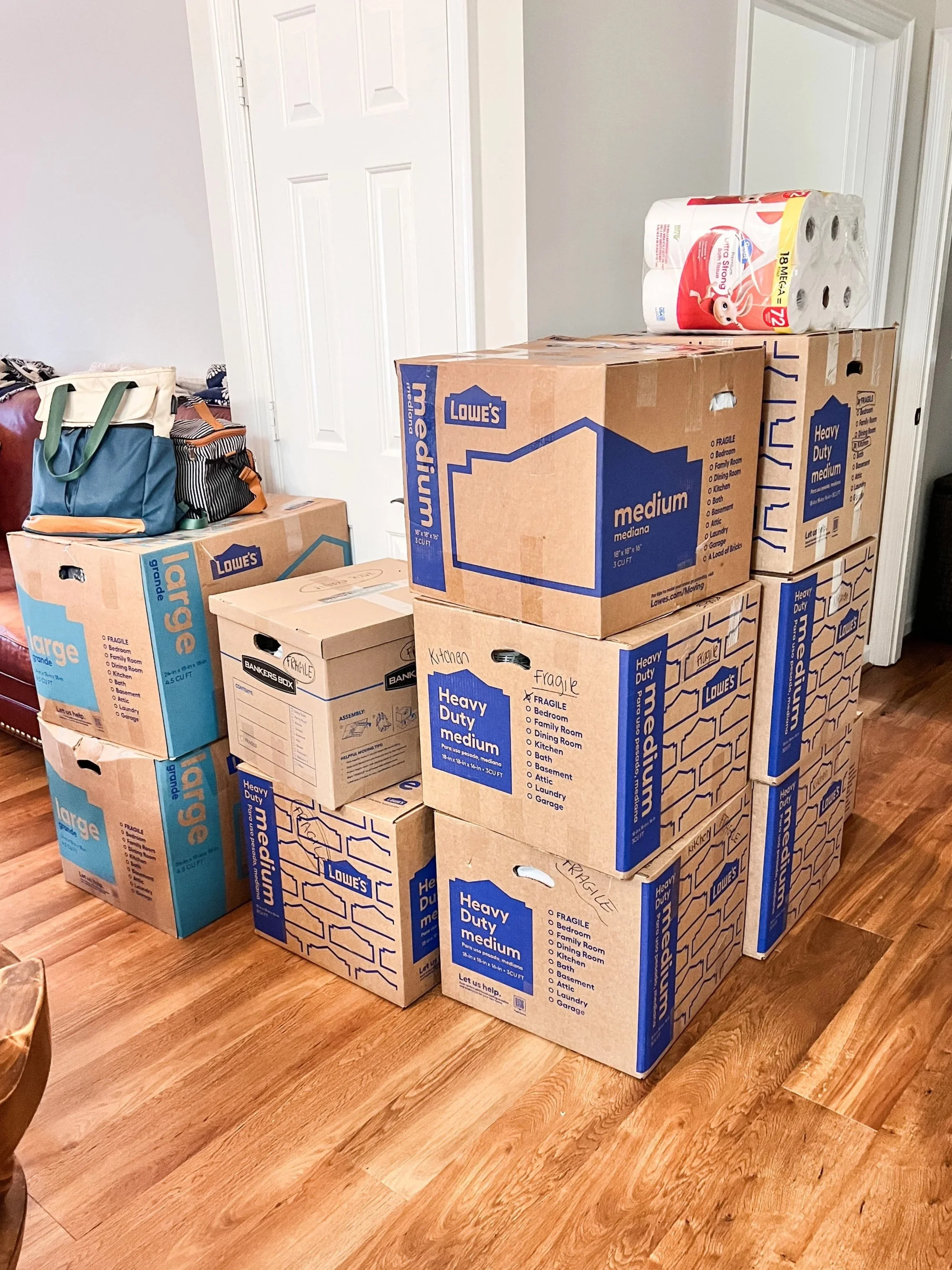 Garage with stacked cardboard moving boxes and shelving units filled with various items.