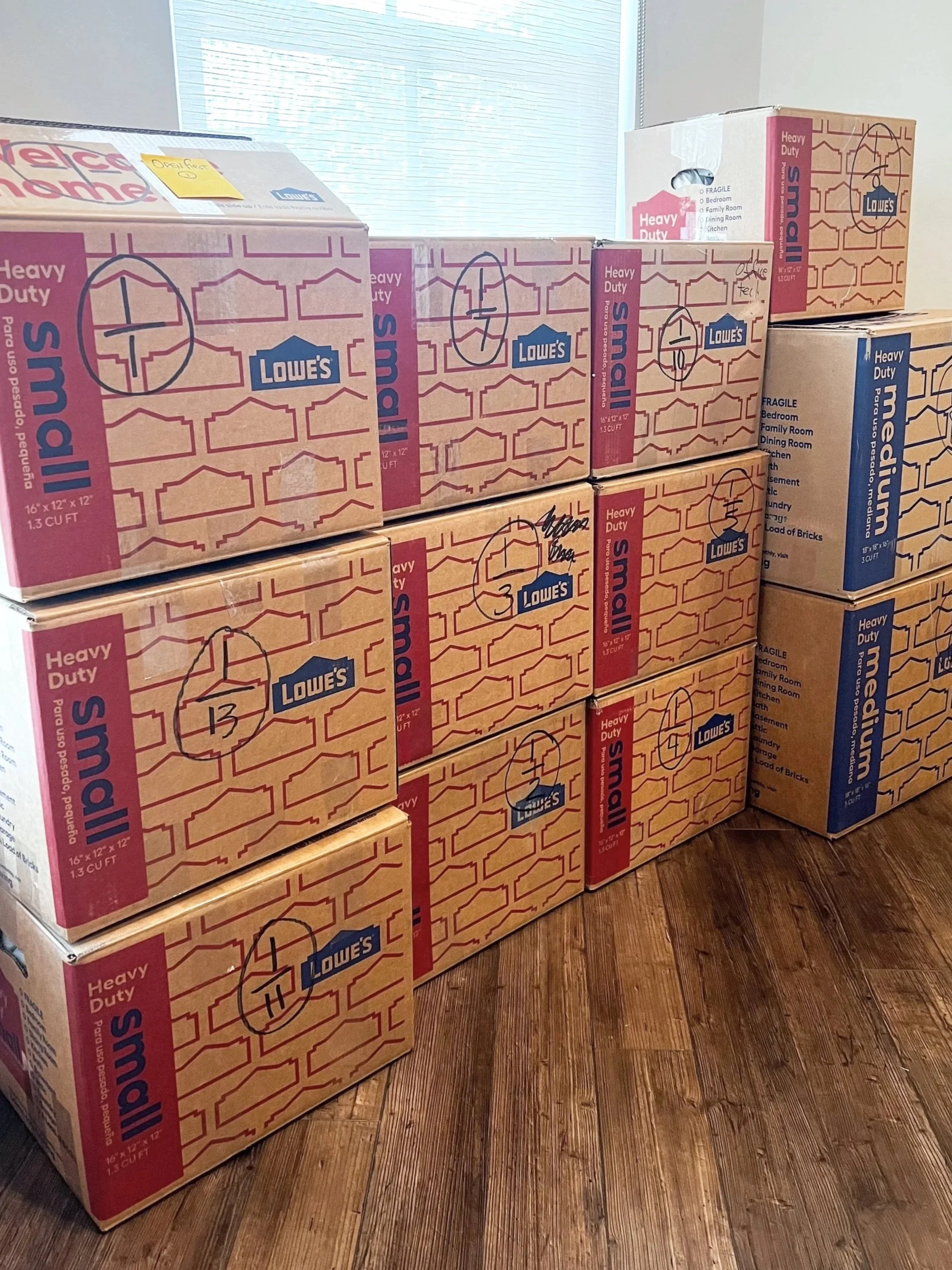 Garage with stacked cardboard moving boxes and shelving units filled with various items.